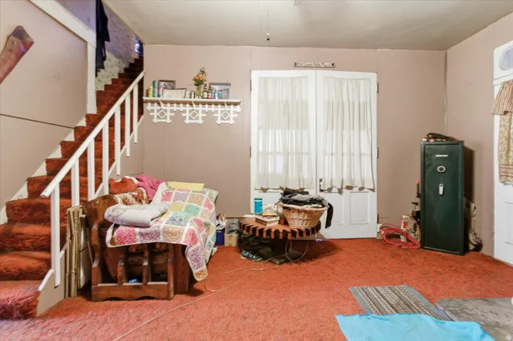 Living area featuring stairs and carpet flooring