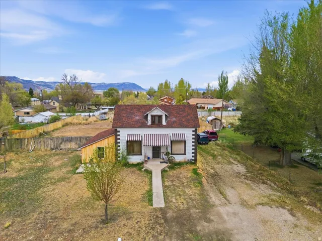 View of front of house featuring covered porch, dirt driveway, and a mountain view