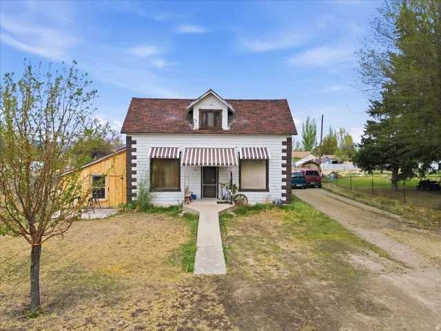 View of front of property with a porch, a front lawn, and driveway