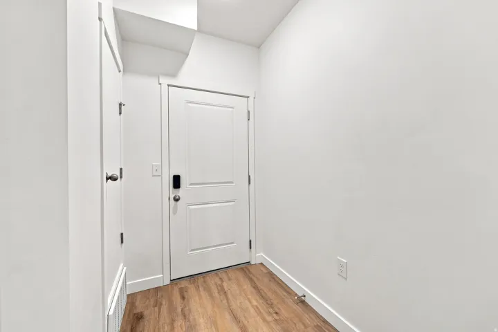 Wood-finish flooring, white paneled doors, and contemporary wall finishes
