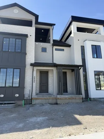 Modern multi-story exterior featuring white brick and dark gray siding