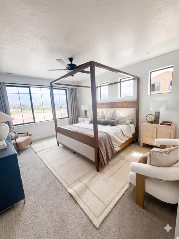 Spacious room featuring broad windows with dark frames, light-toned carpet flooring, a ceiling fan with light fixture, and recessed lighting
