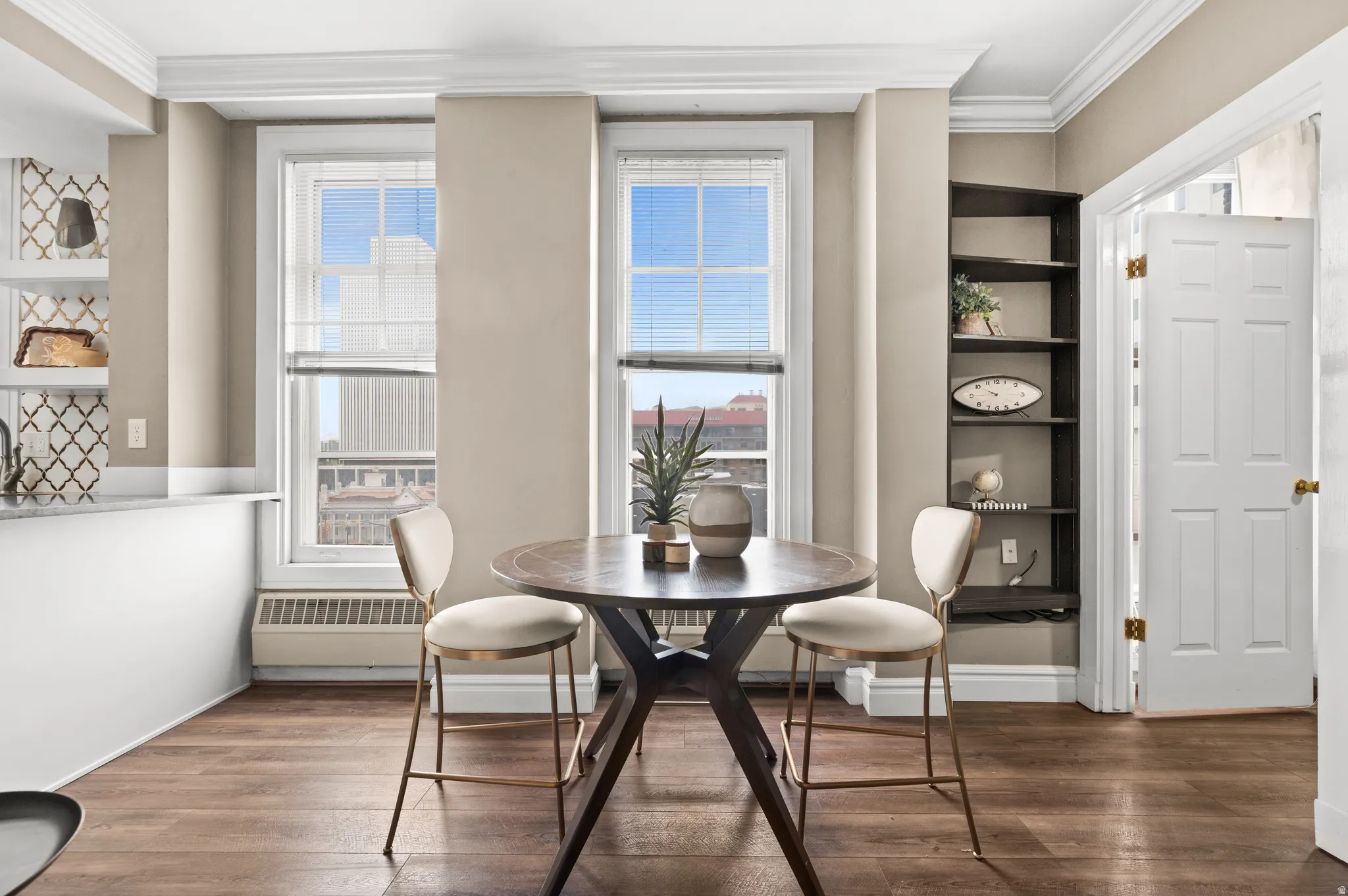 Dining space featuring crown molding, dark wood-style floors, and radiator heating unit