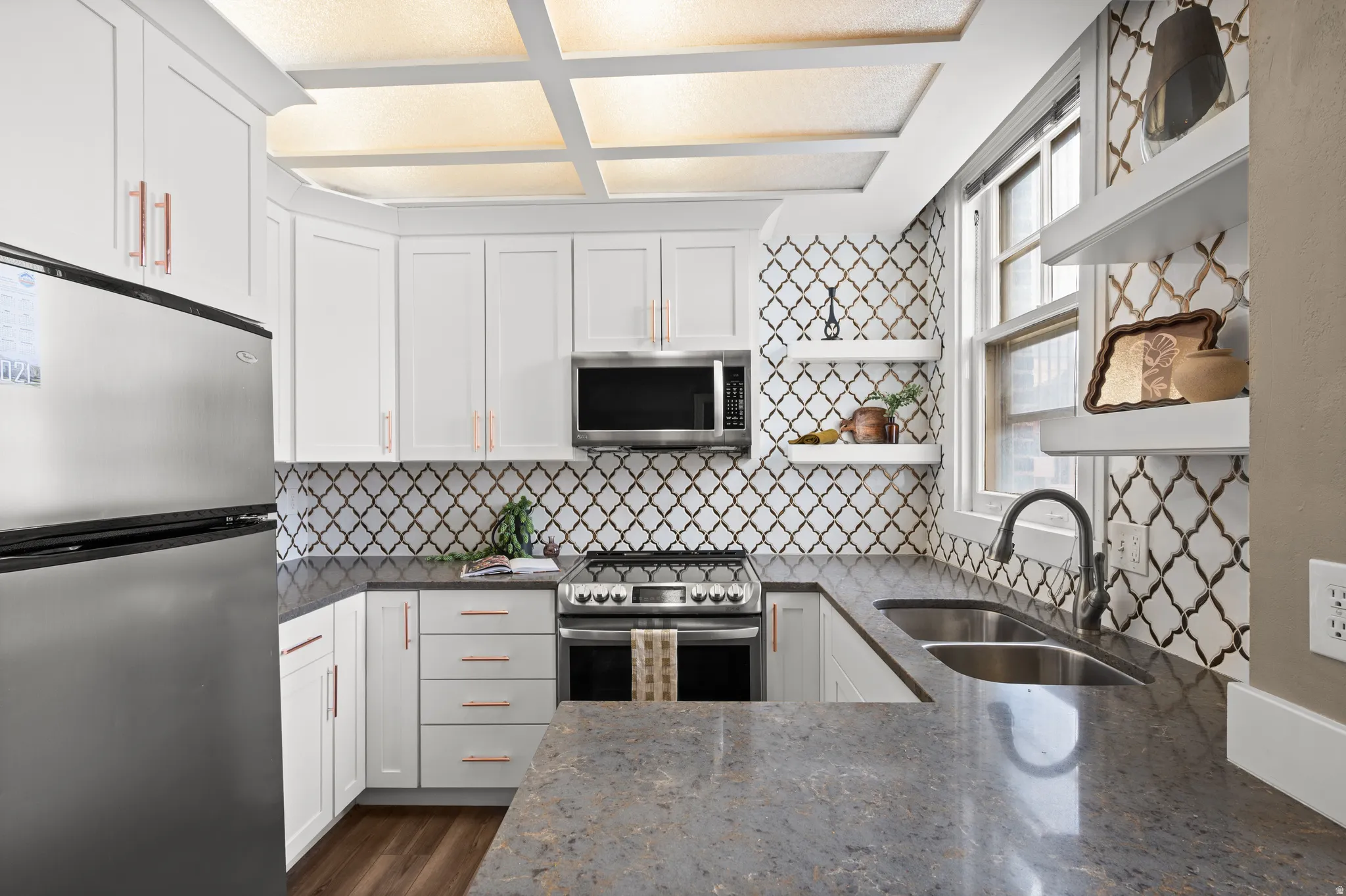 Kitchen featuring open shelves, stainless steel appliances, dark stone countertops, white cabinetry, and dark wood-style floors
