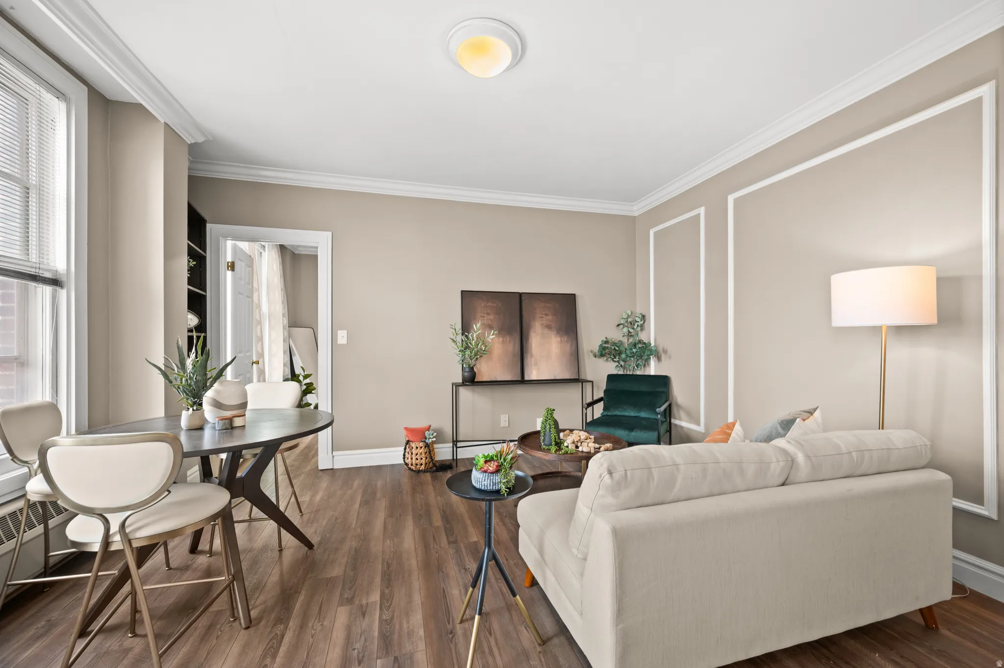 Living room featuring dark wood-type flooring, ornamental molding, and baseboard heating