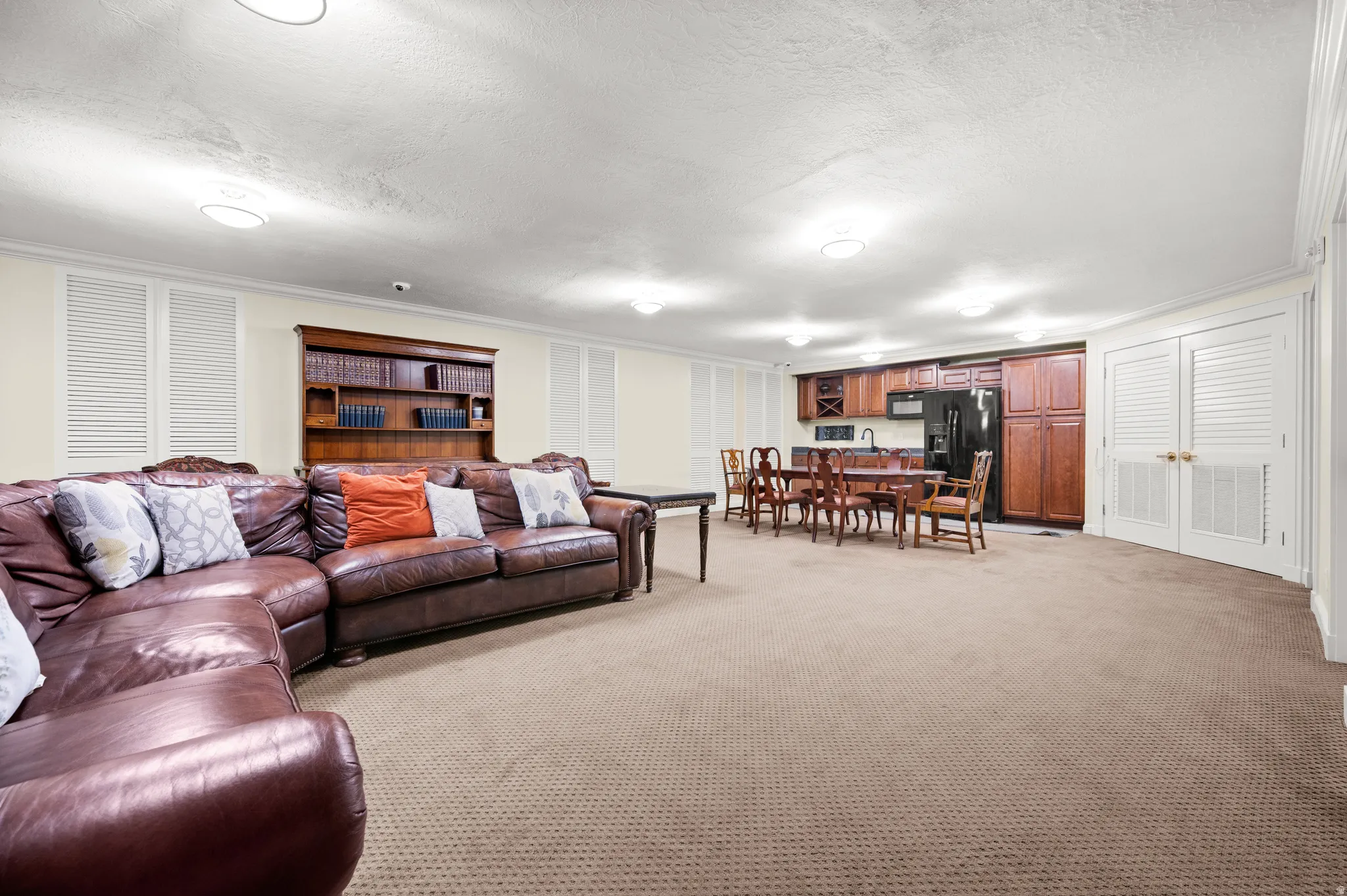 Living room featuring ornamental molding, light colored carpet, and a textured ceiling