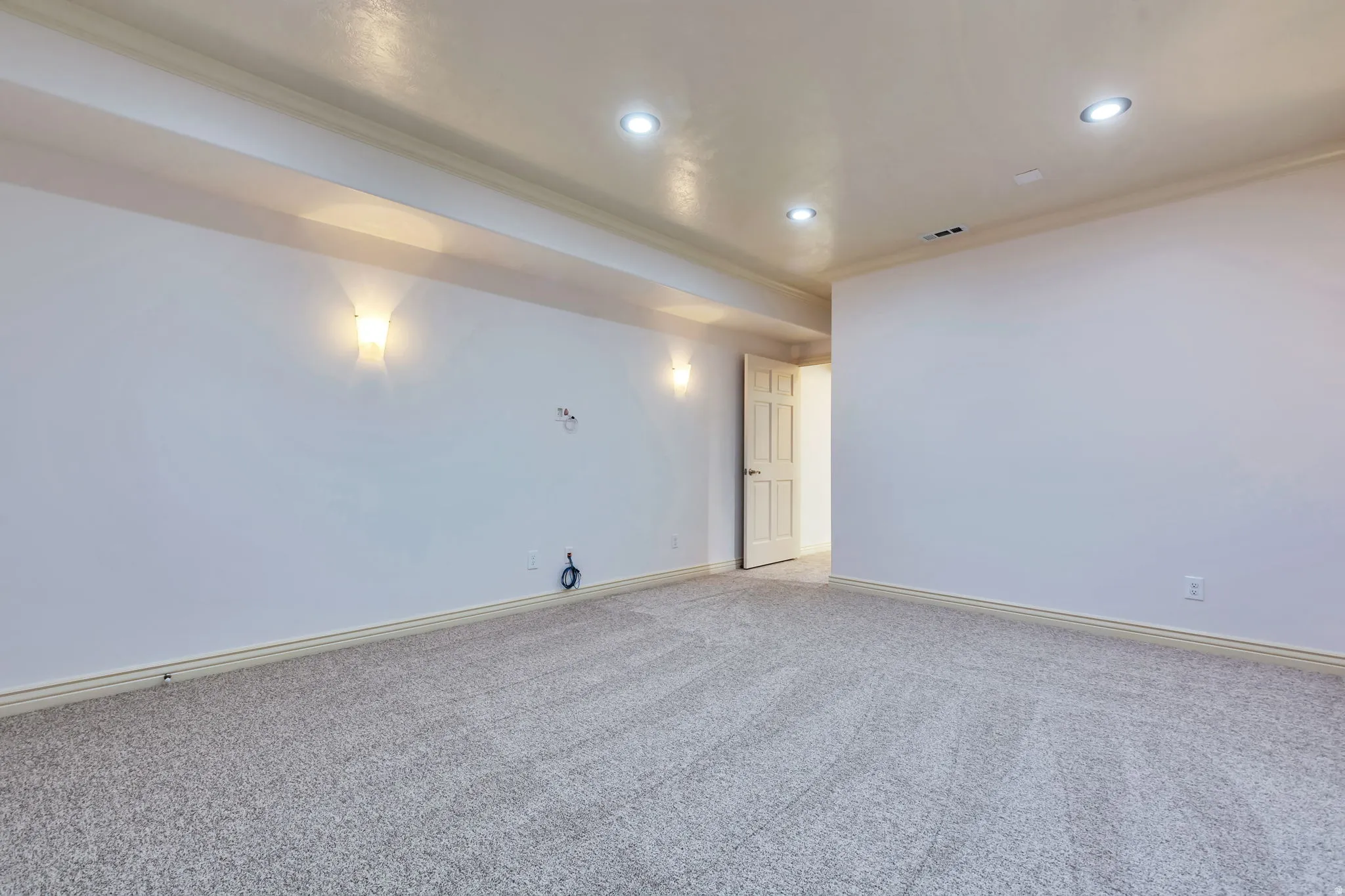 Empty room with ornamental molding, light carpet, and recessed lighting