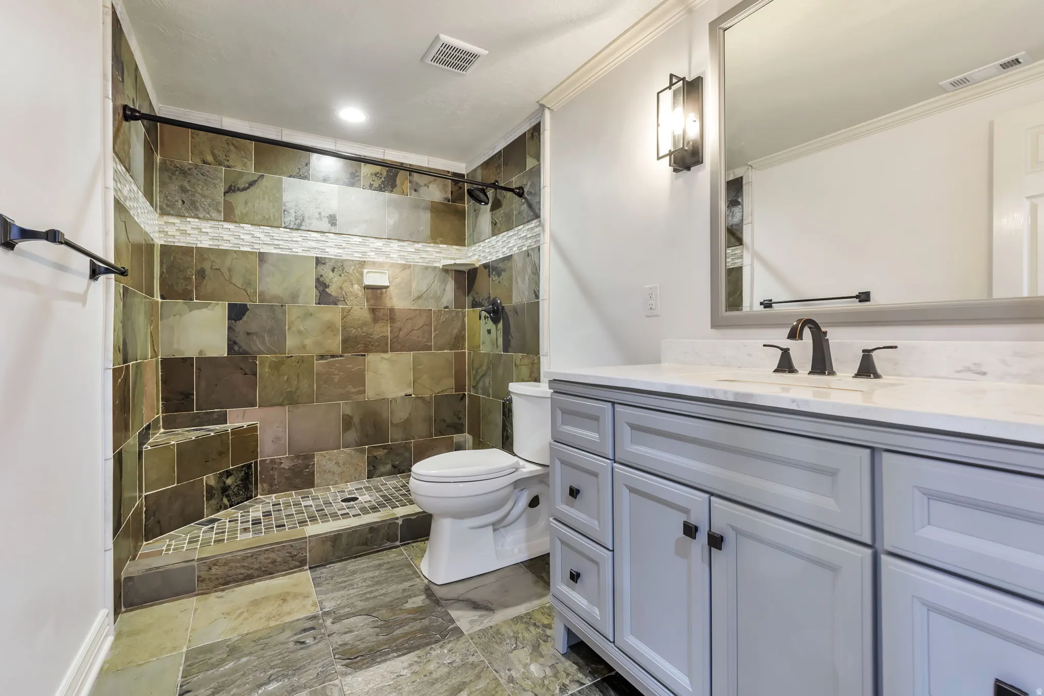 Bathroom featuring vanity, a shower stall, crown molding, and recessed lighting