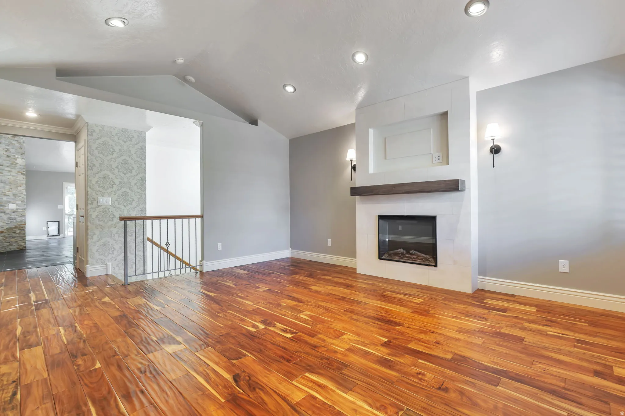 Unfurnished living room featuring wood finished floors and a large fireplace