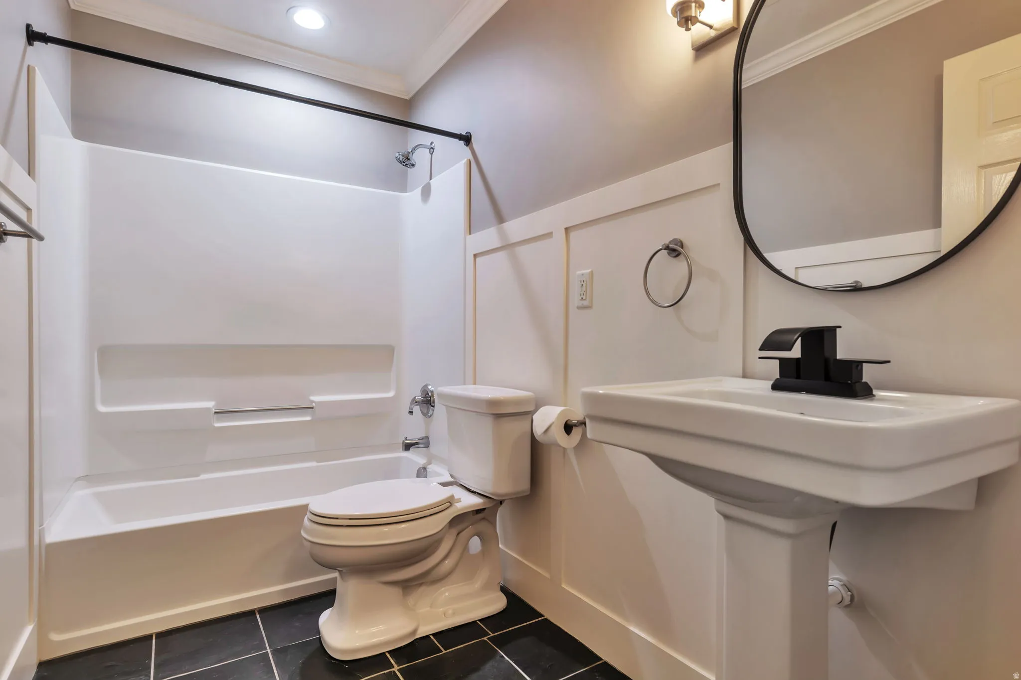 Full bathroom featuring crown molding, bathtub / shower combination, and dark tile patterned flooring