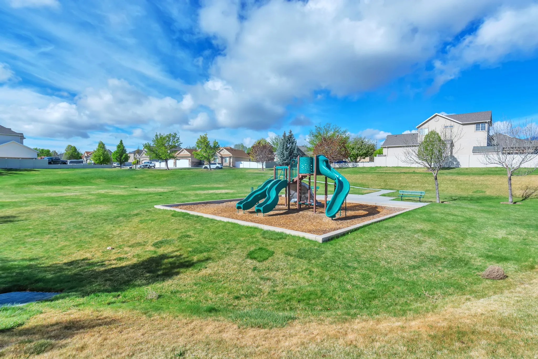 Communal playground featuring a residential view and a lawn