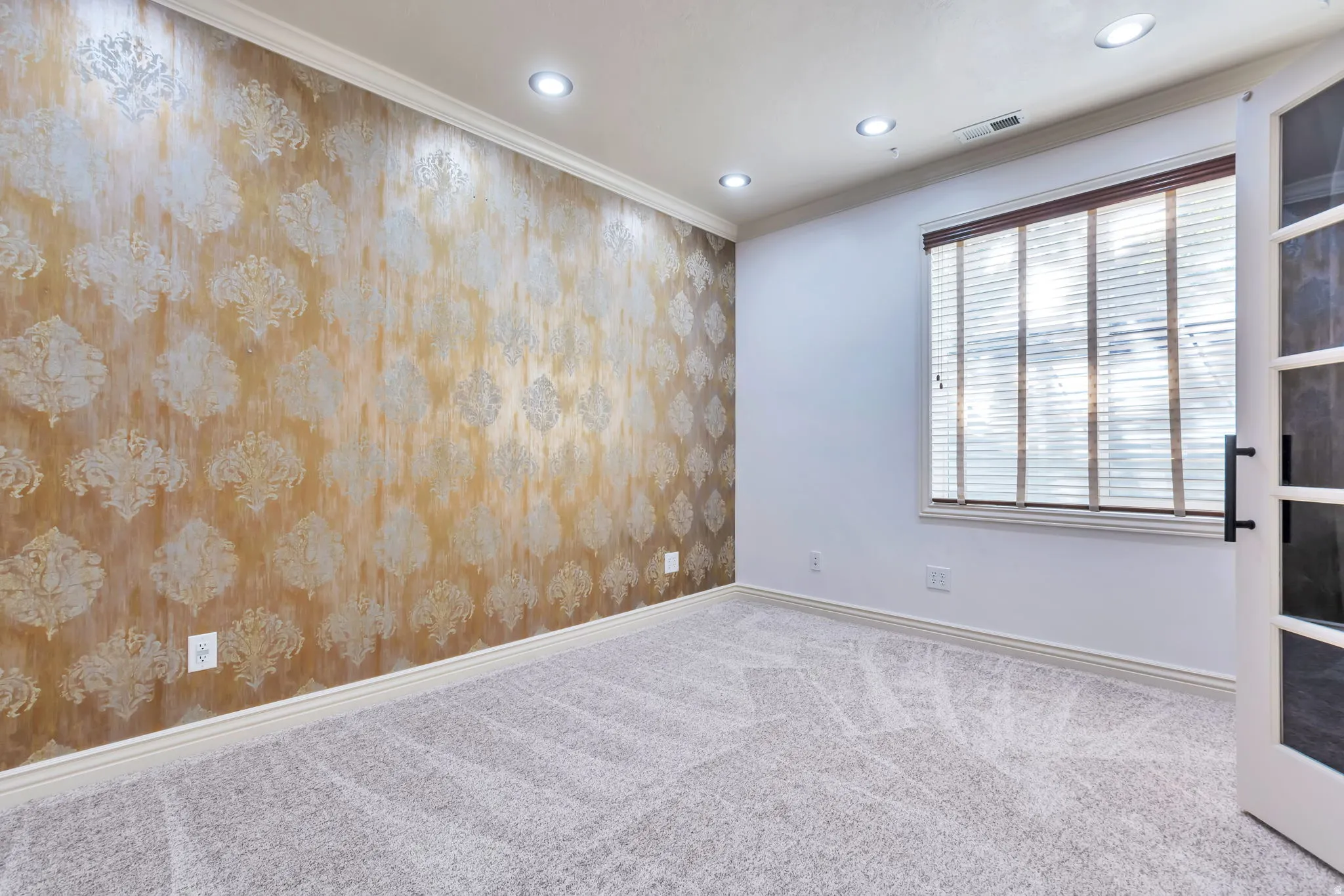 Spare room with crown molding, carpet floors, recessed lighting, and wallpapered walls