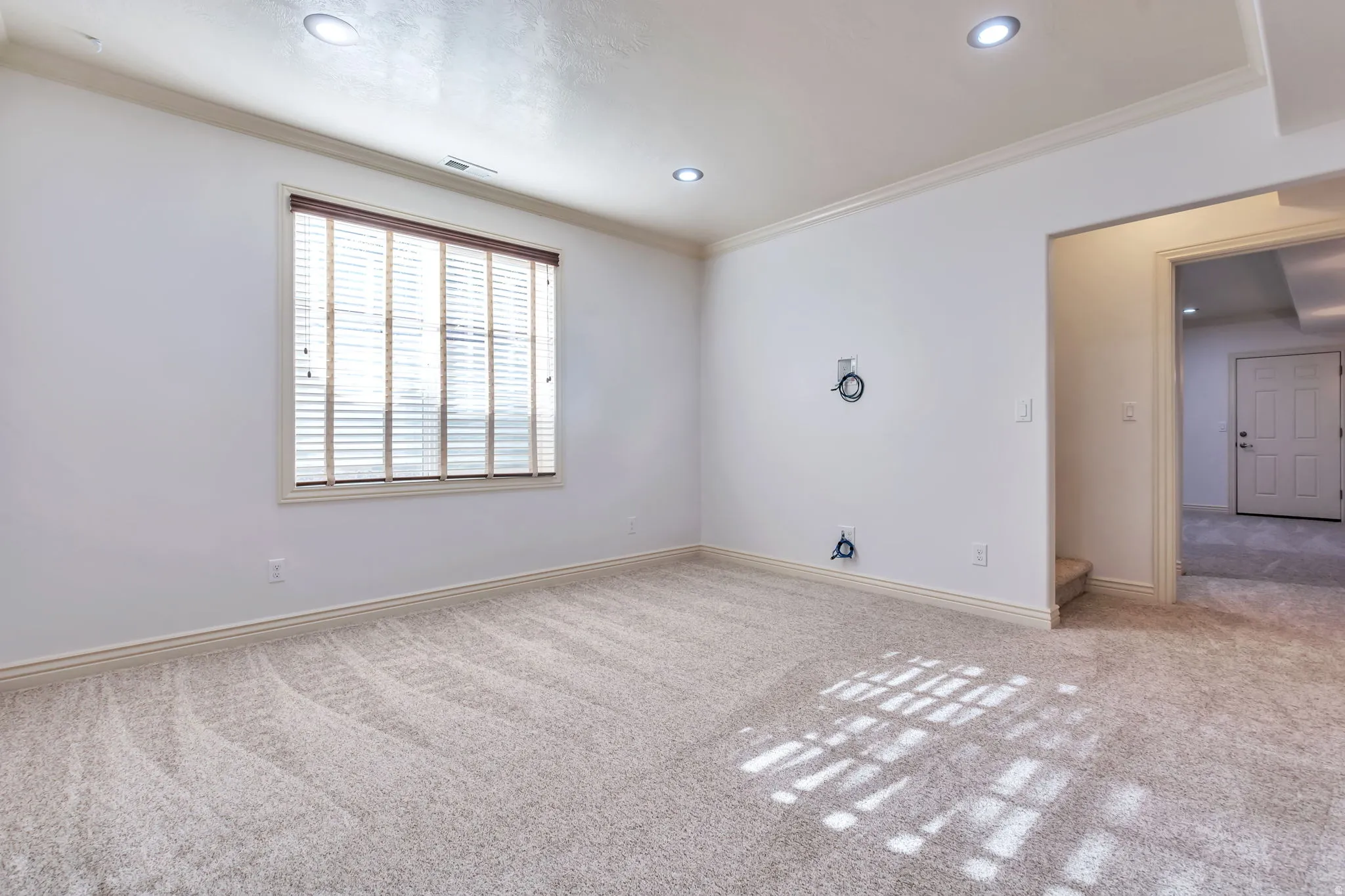Unfurnished room featuring light carpet, crown molding, and recessed lighting