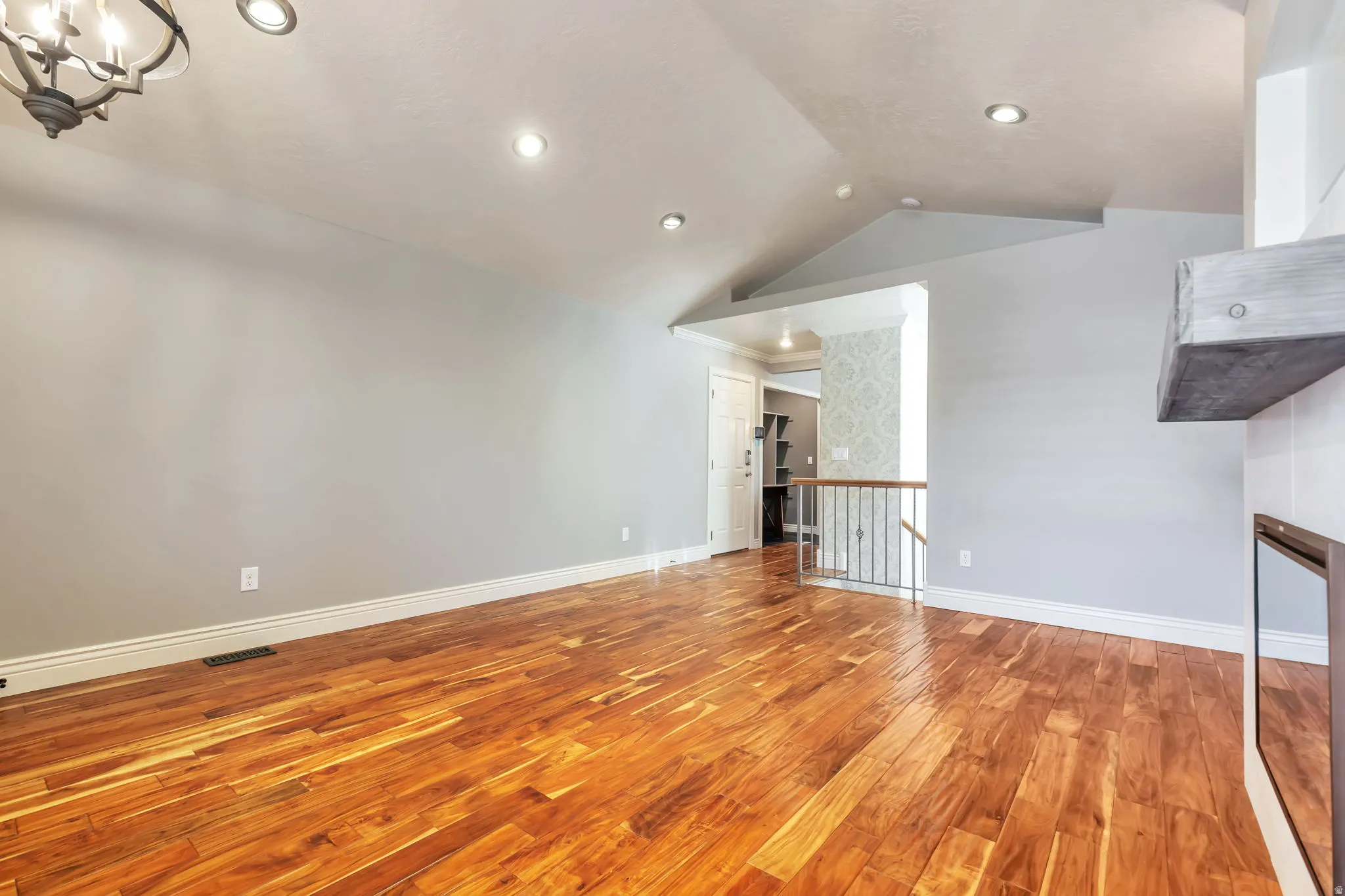 Unfurnished living room with wood-type flooring and a chandelier