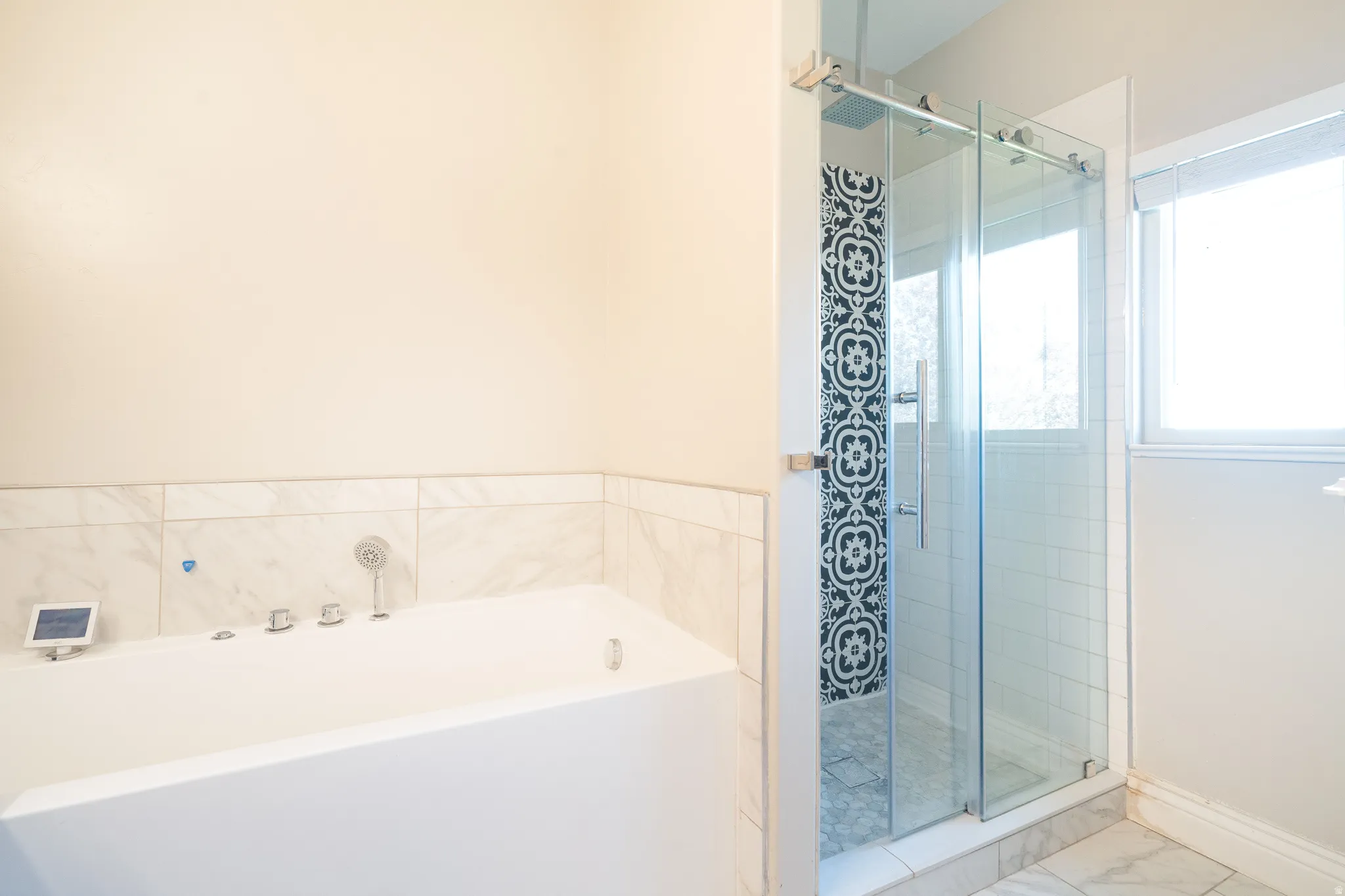 Bathroom featuring a stall shower, a bath, and marble look tiles