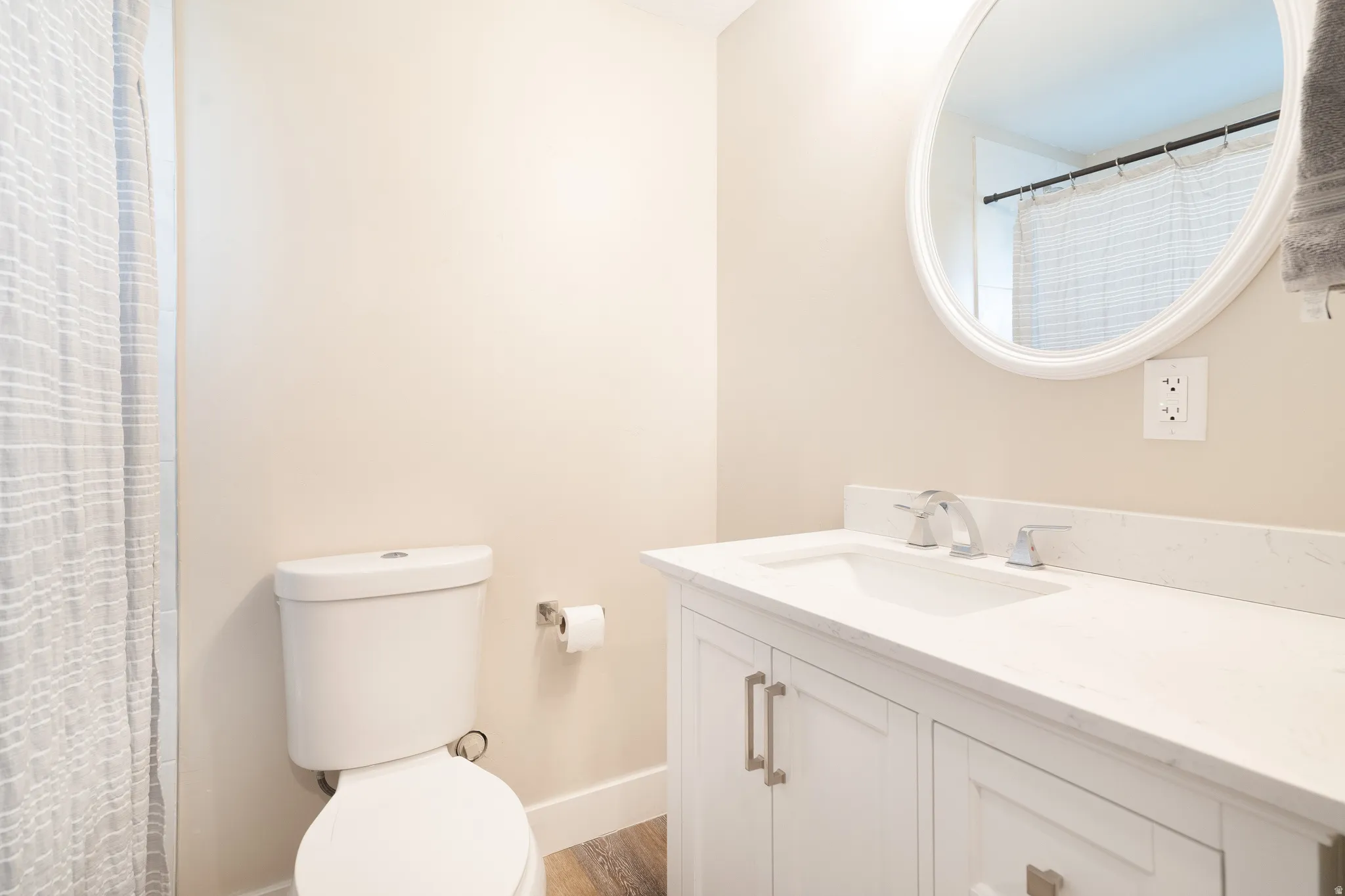 Full bath featuring vanity, curtained shower, and dark wood-style floors