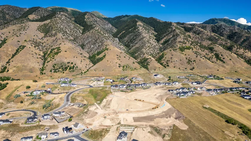 Expansive mountain backdrop with scattered new construction and developed roads