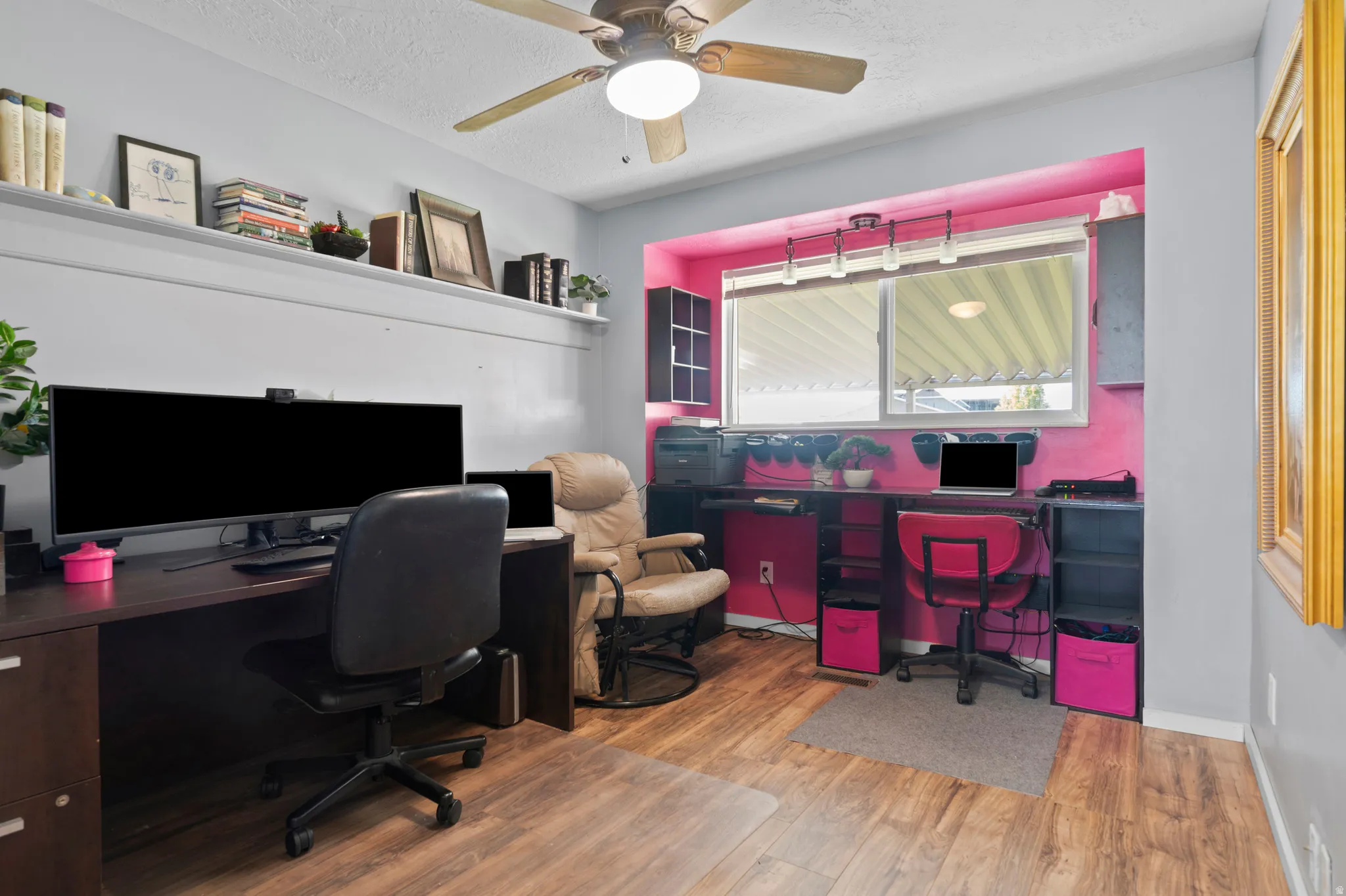 Office space featuring ceiling fan, light wood-style floors, a textured ceiling, and built in desk