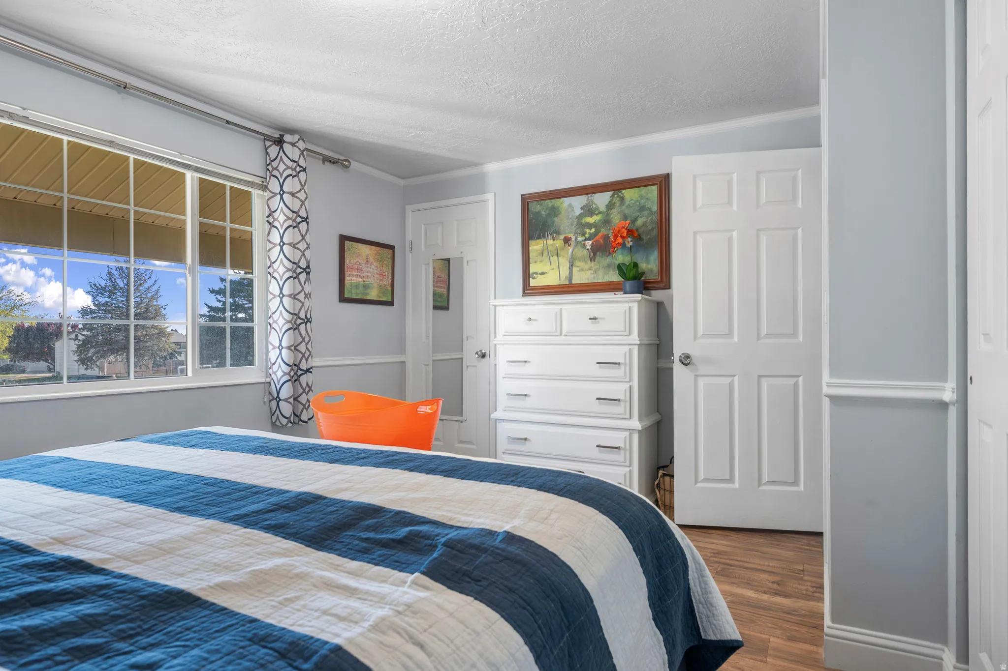 Bedroom with dark wood-style flooring and a textured ceiling