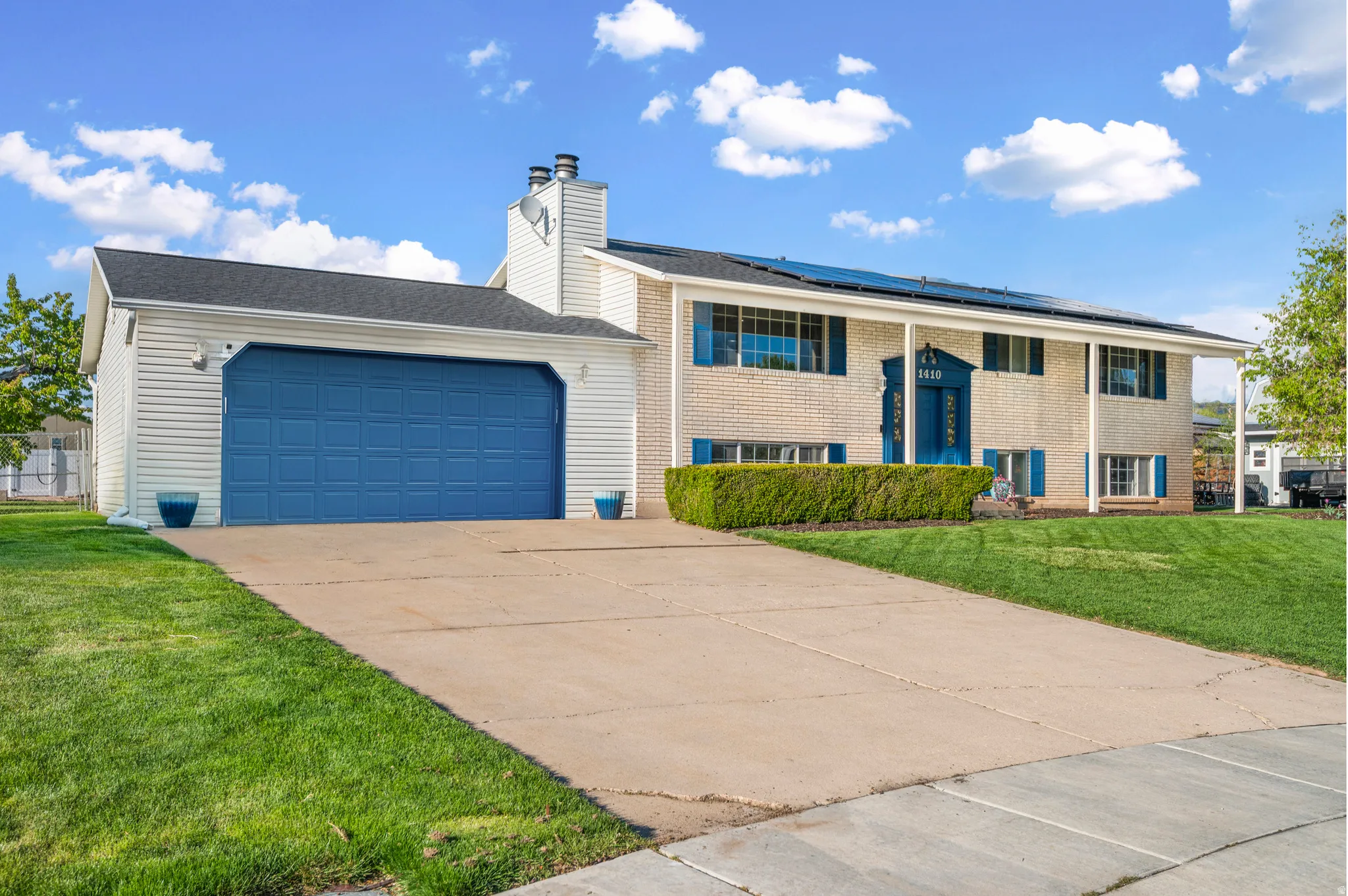 Split-level residence featuring a two-car garage with a blue paneled door
