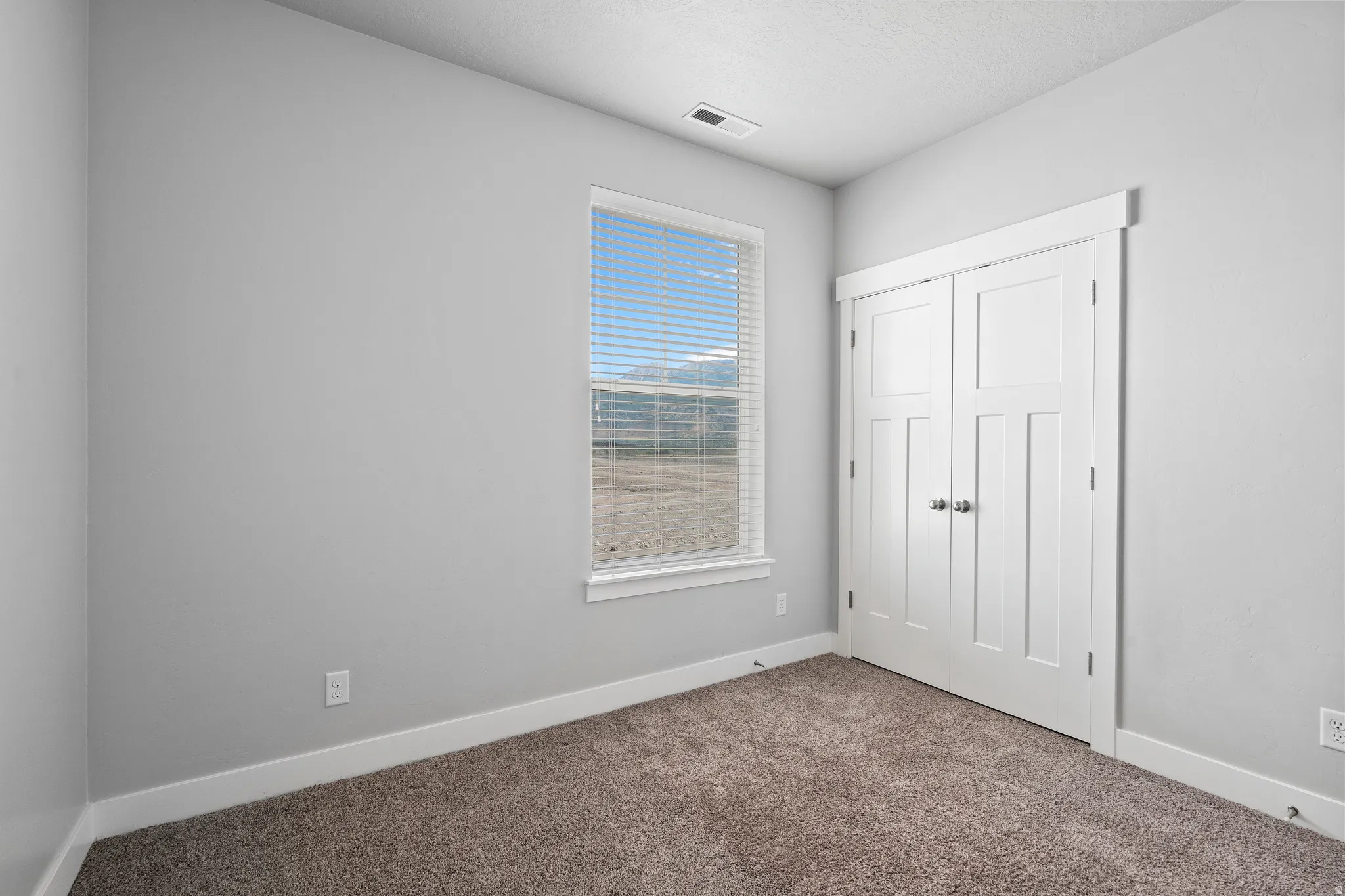 Unfurnished bedroom featuring carpet, a closet, and a textured ceiling