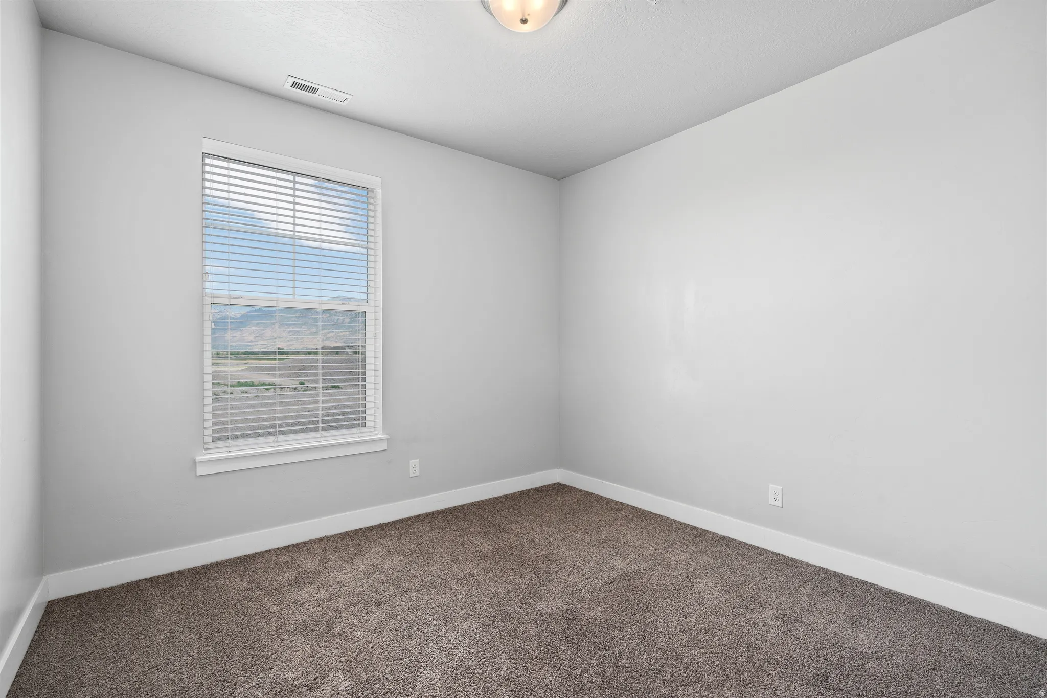 Unfurnished room featuring dark carpet and baseboards