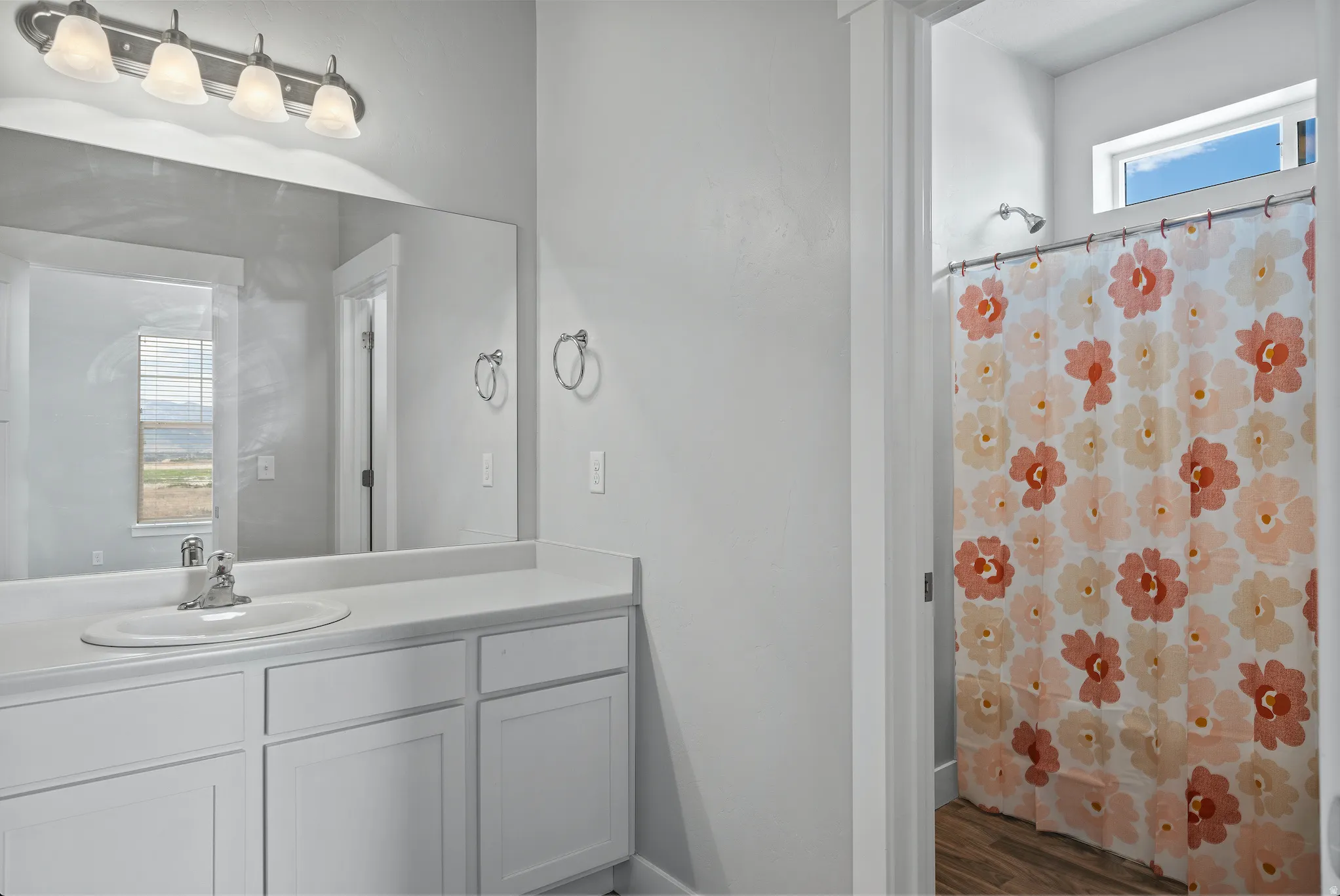 Bathroom with vanity, a shower with shower curtain, and dark wood finished floors