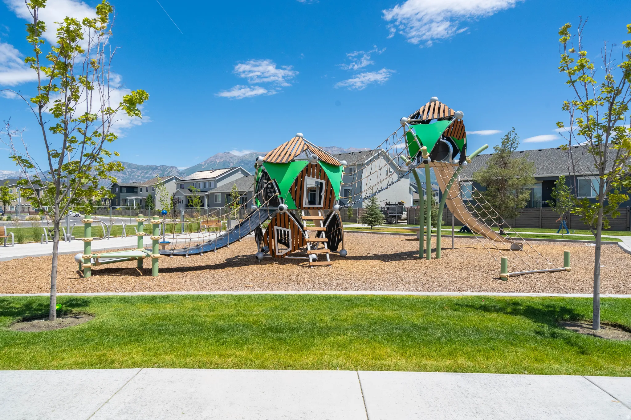 Communal playground with a yard and a residential view