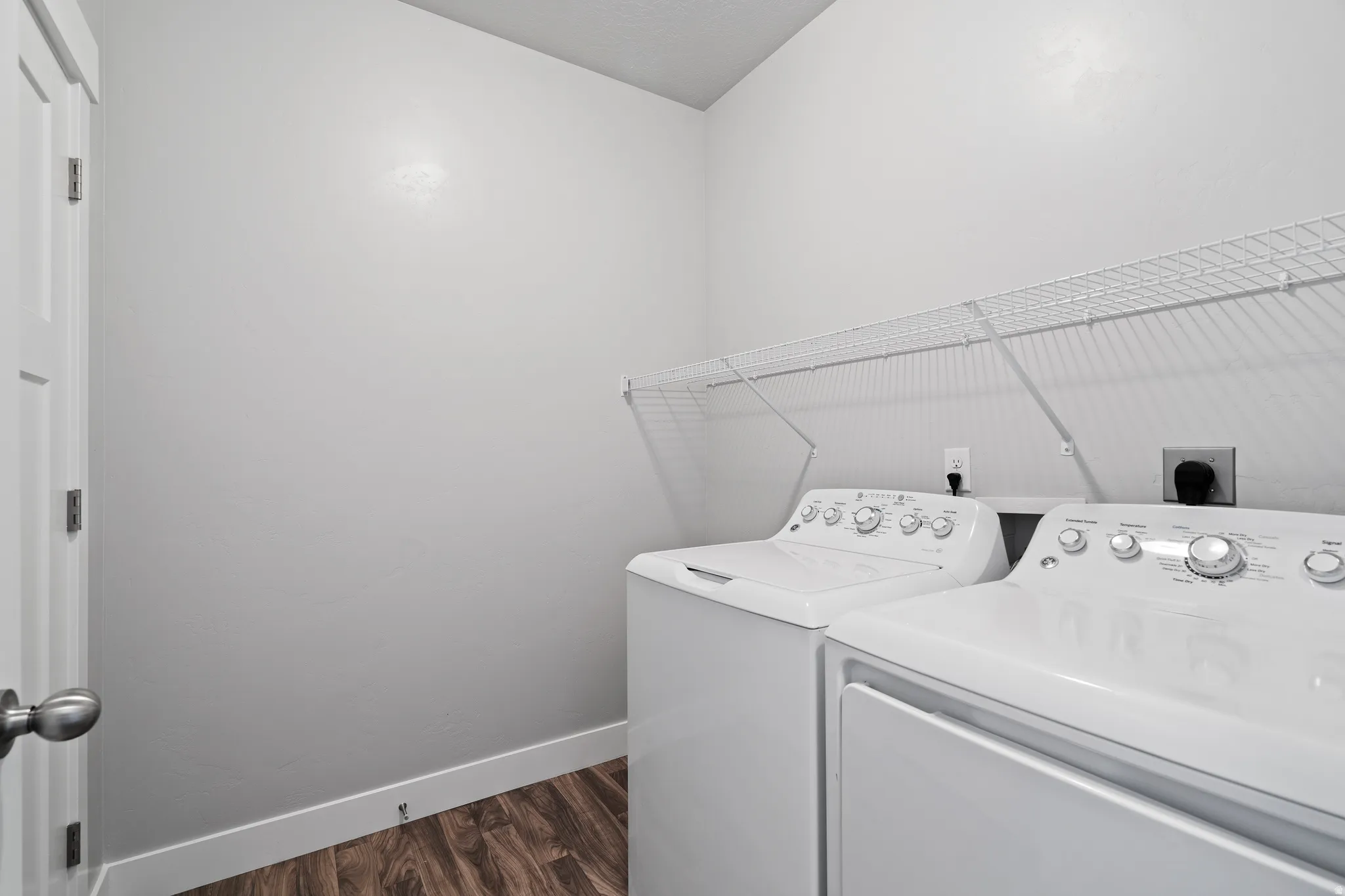 Laundry area featuring dark wood finished floors and separate washer and dryer