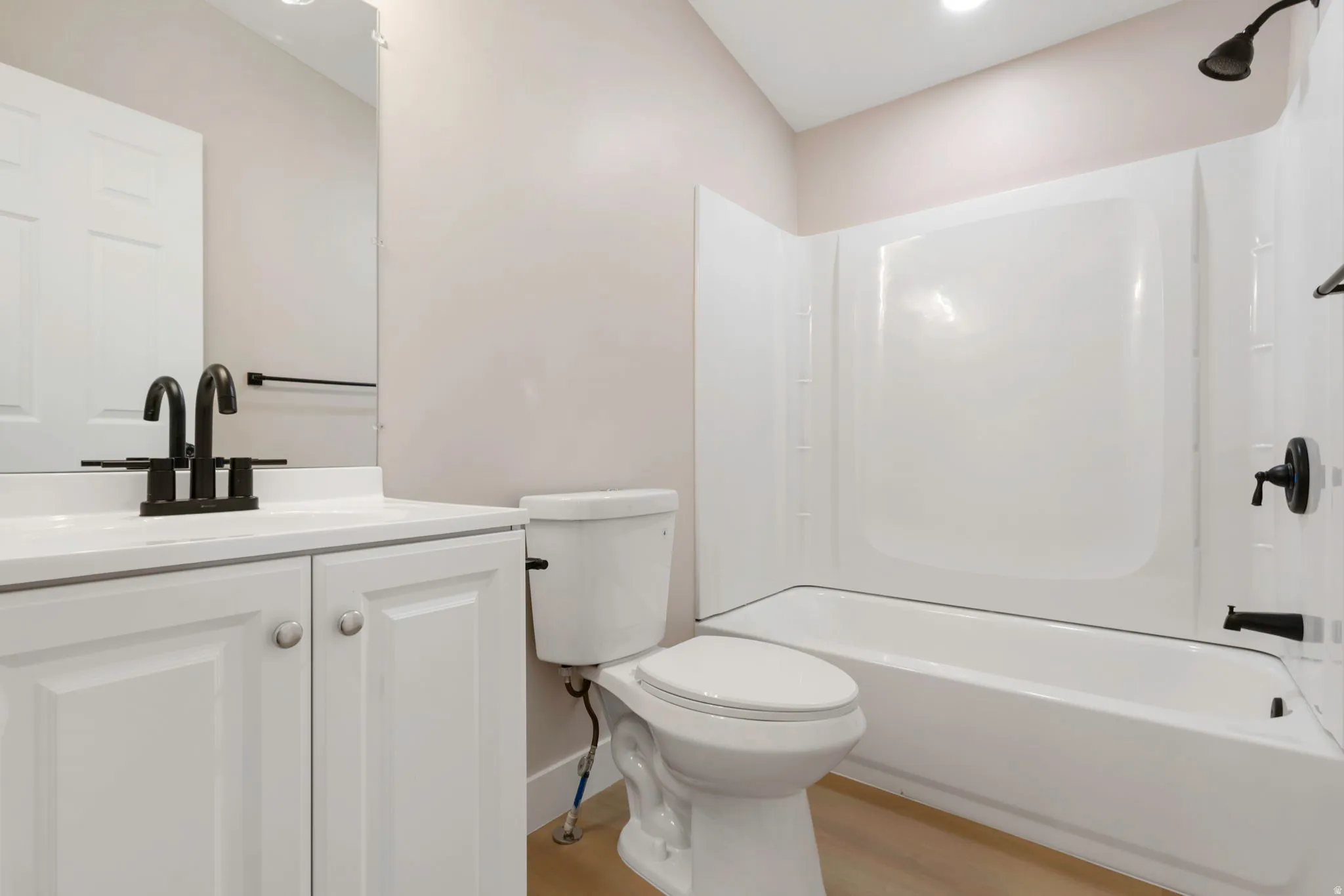 Bathroom with vanity, light wood finished floors, and shower / bathtub combination