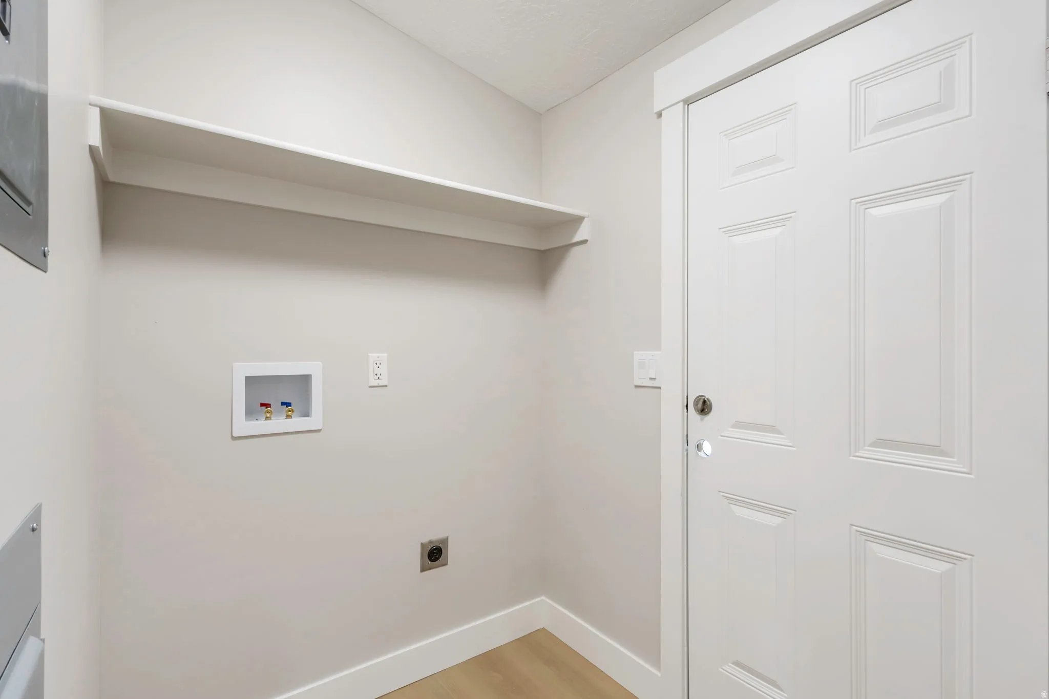 Laundry area featuring light wood-type flooring, hookup for a washing machine, and hookup for an electric dryer
