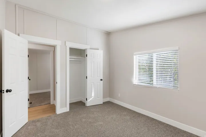 Unfurnished bedroom featuring light carpet and a closet
