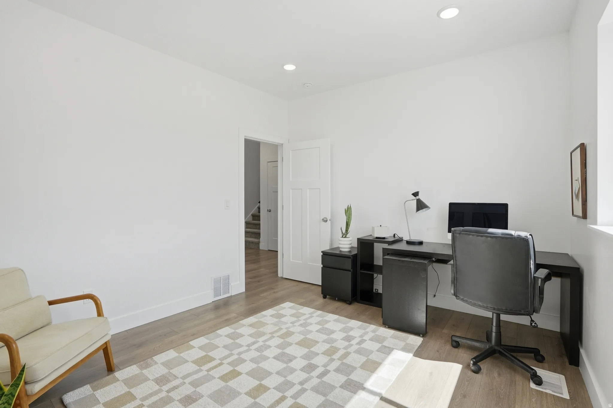 Bedroom 1 or Home office with light wood-style flooring and recessed lighting