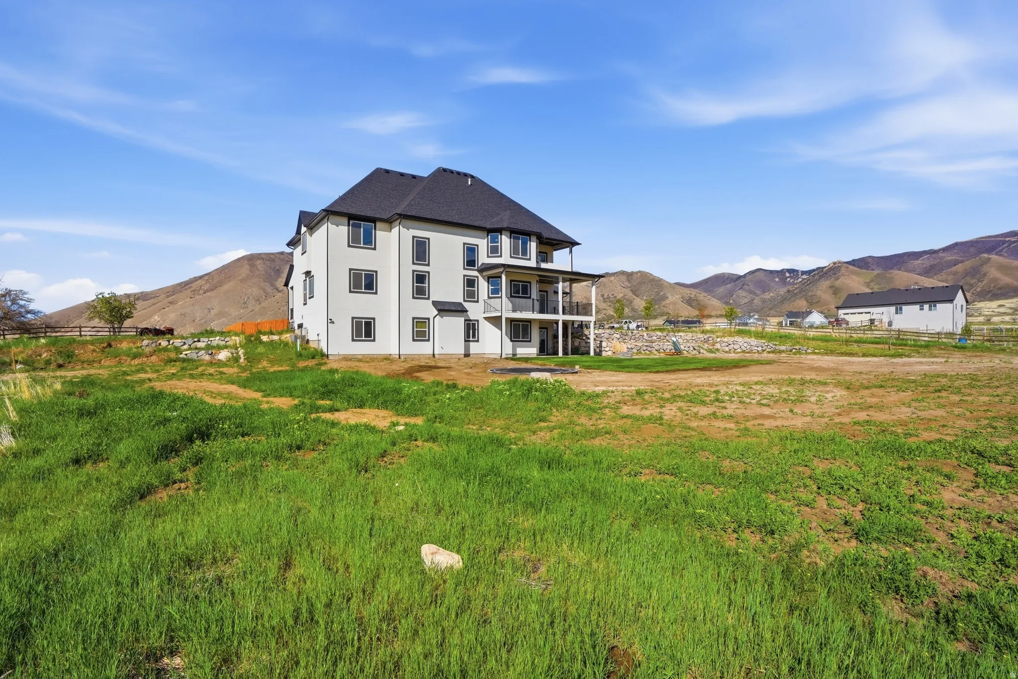 Back of property with a mountain view, a balcony, and stucco siding