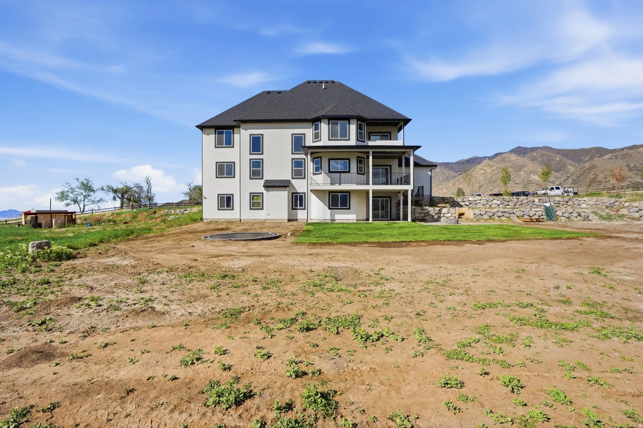 Back of property with a mountain view, stucco siding, and a balcony