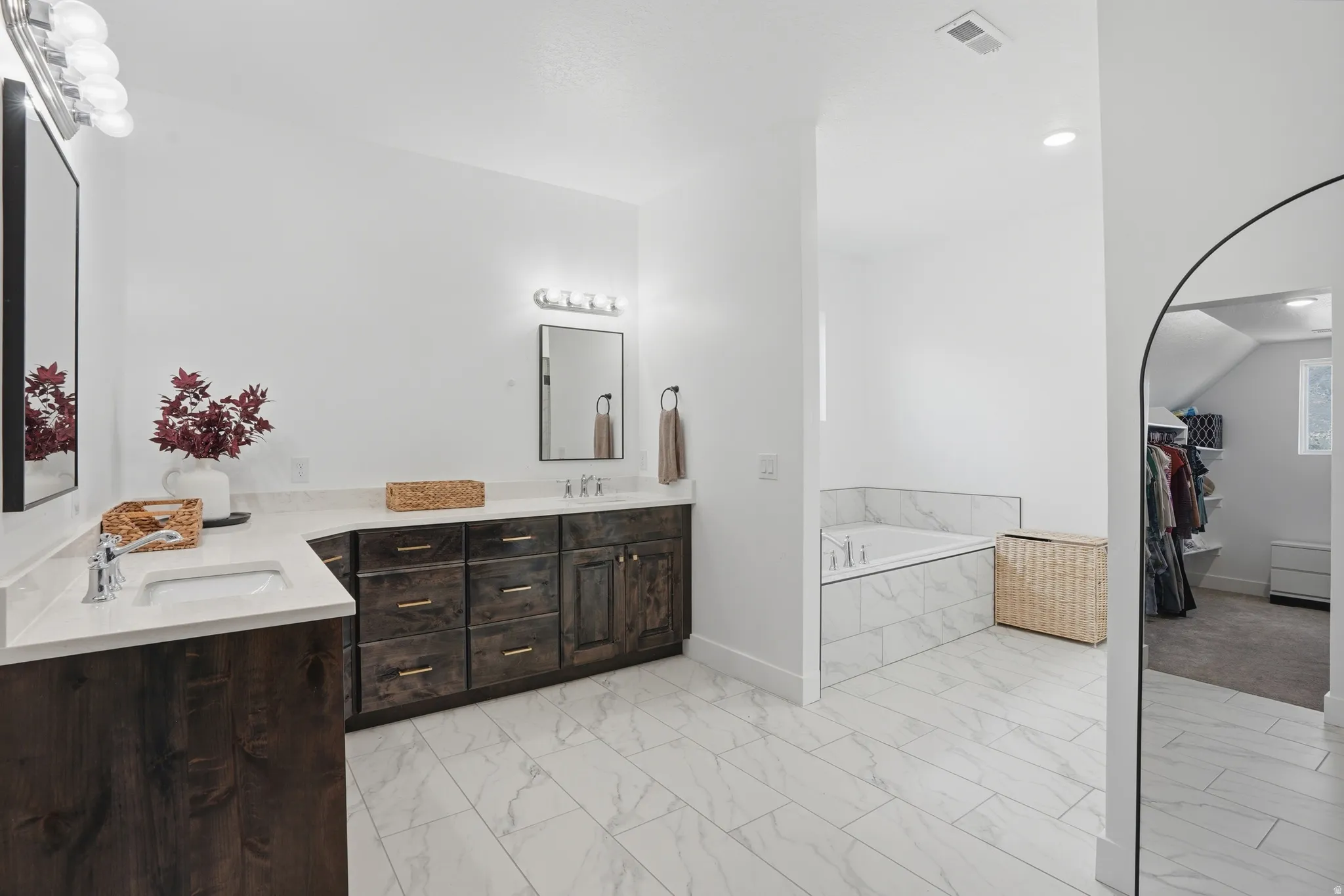 Bathroom with double vanity, a garden tub, a walk in closet, light marble finish flooring, and recessed lighting