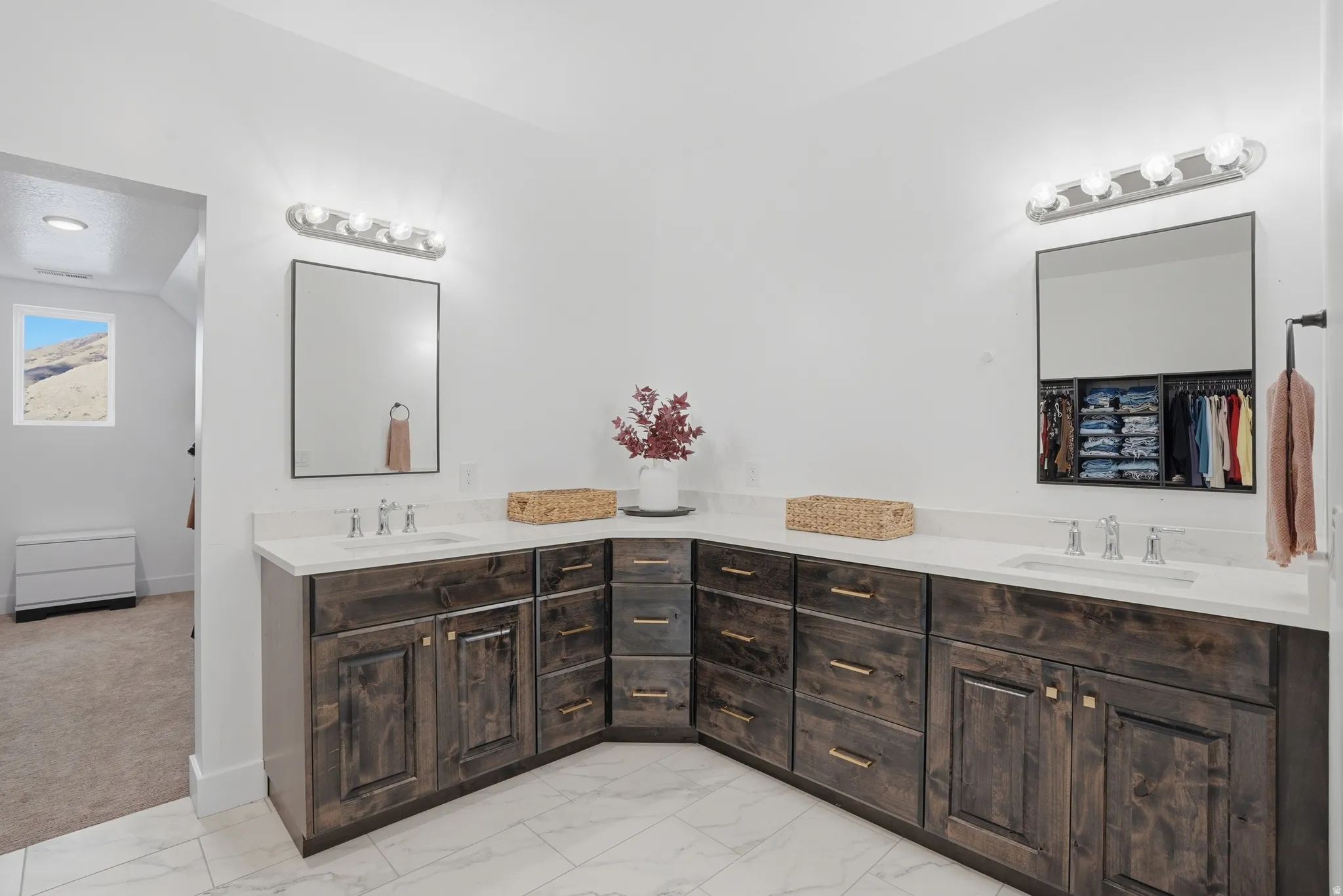 Full bathroom with double vanity, light marble finish flooring, and light colored carpet