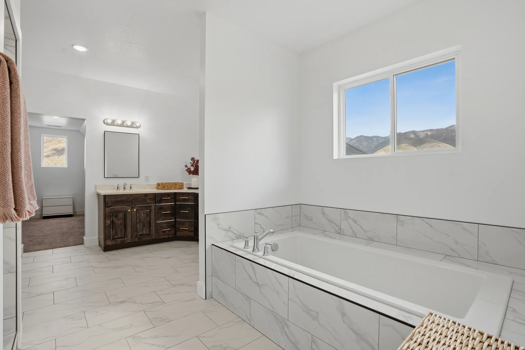 Full bathroom with vanity, a bath, light marble finish flooring, plenty of natural light, and recessed lighting