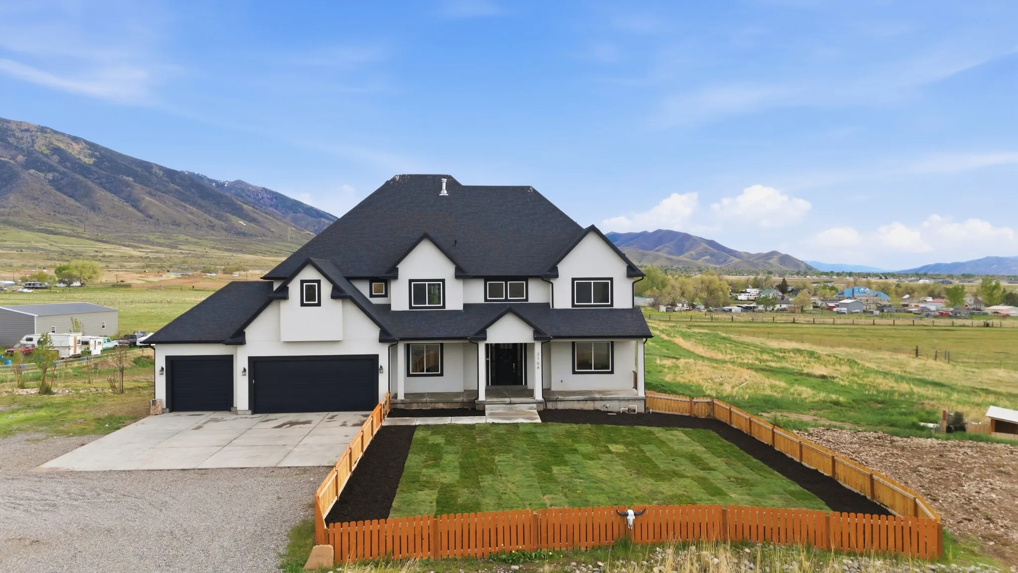 Modern inspired farmhouse with driveway, a mountain view, stucco siding, and an attached garage