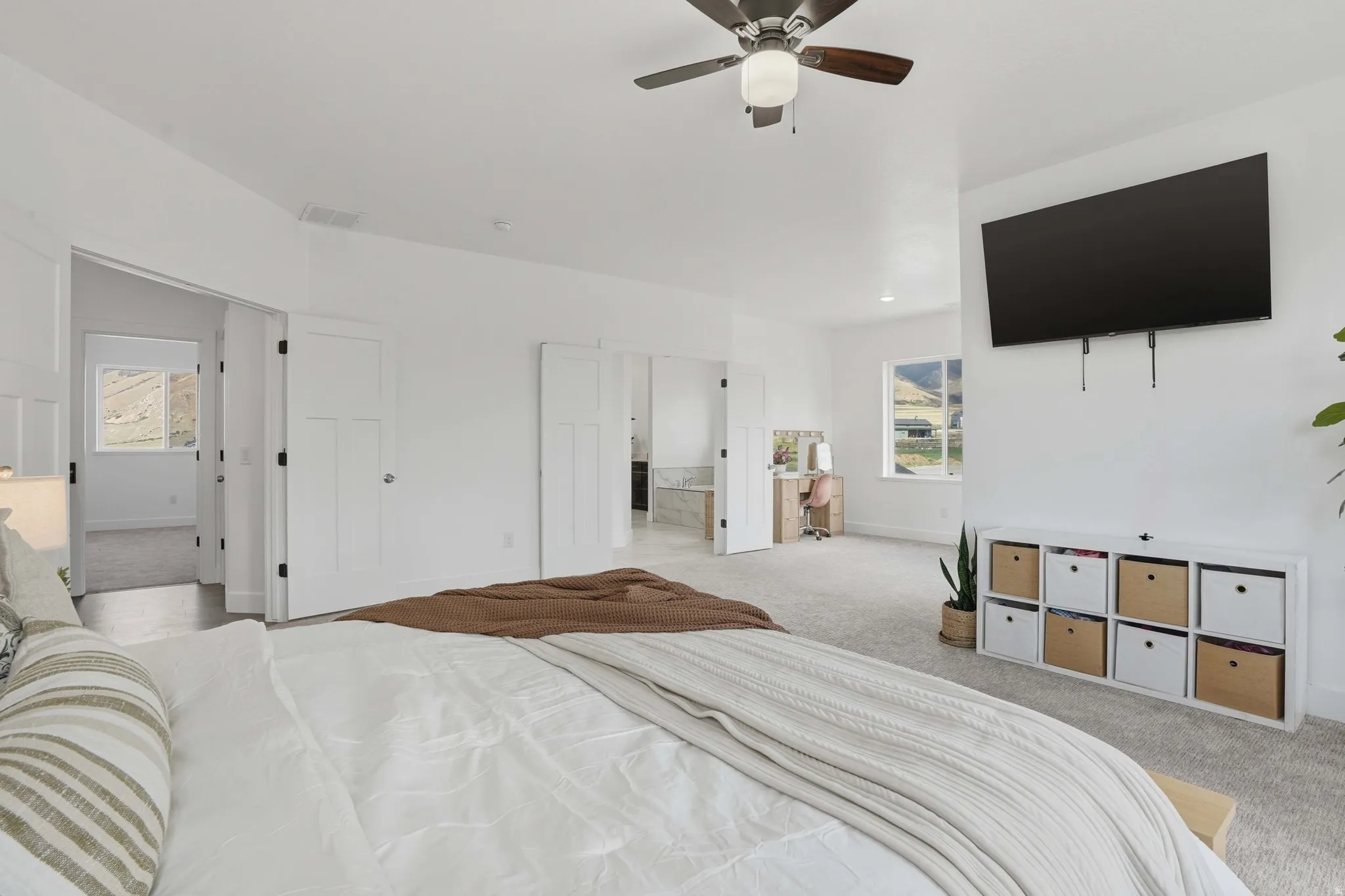 Master Bedroom featuring light colored carpet, a ceiling fan, and multiple windows
