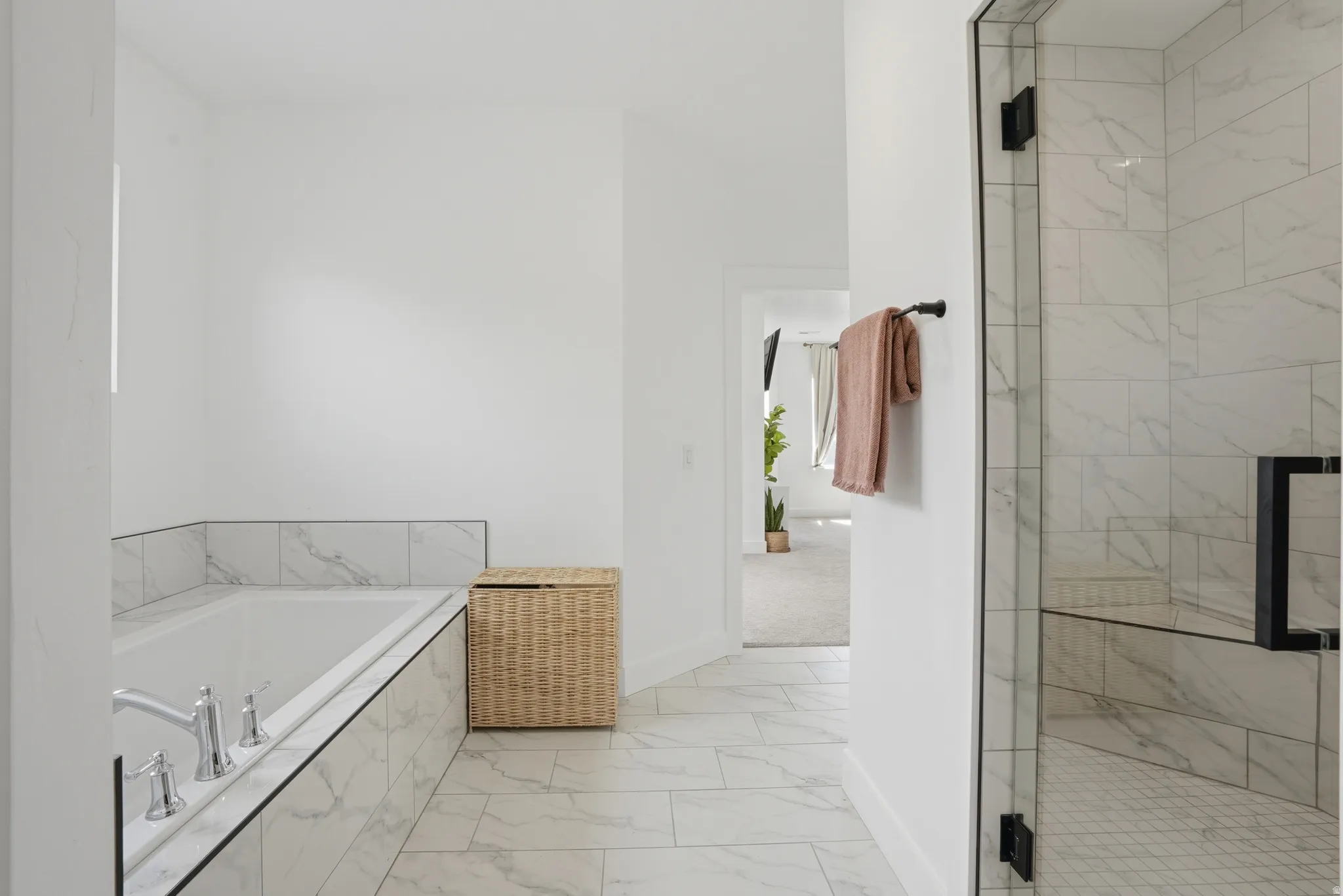 Bathroom featuring a marble finish shower, light marble finish floors, and a garden tub