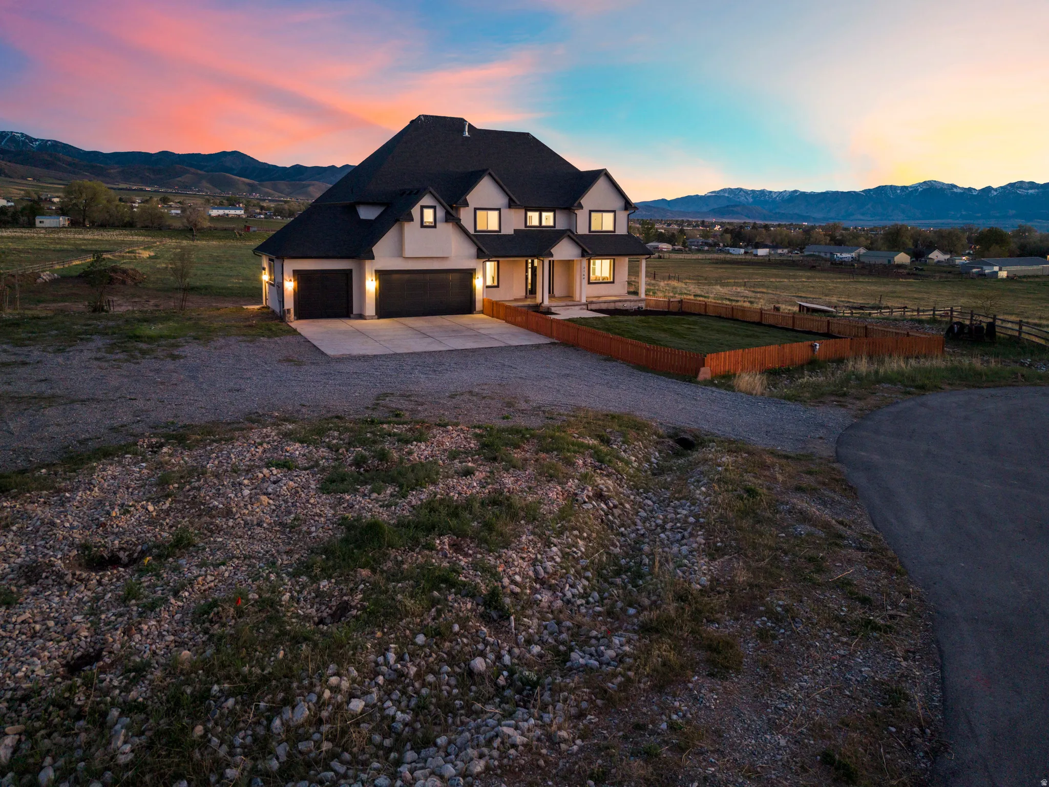 View of front of home with driveway, a mountain view, and a view of countryside