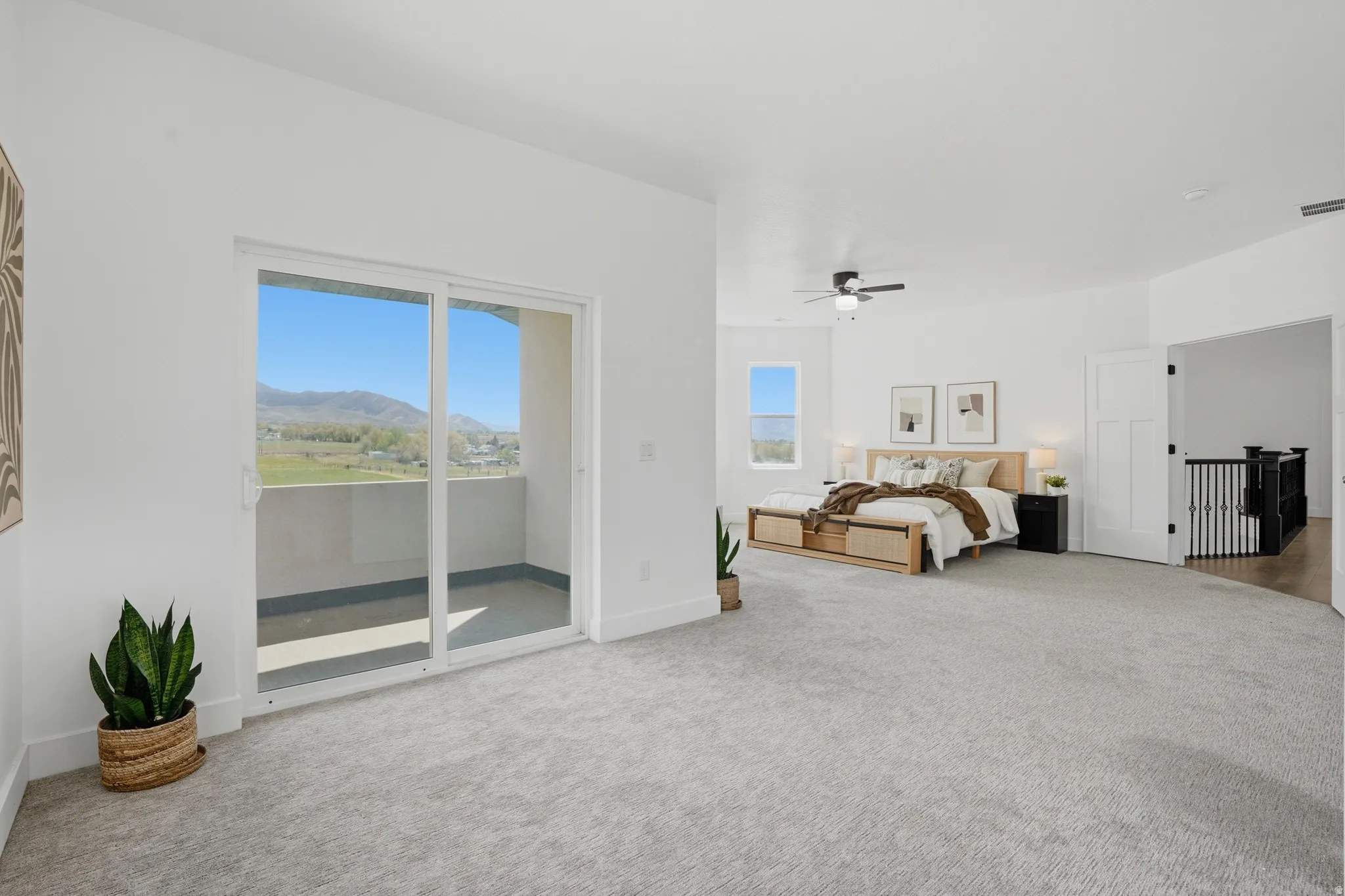 Master Bedroom featuring light colored carpet, access to outside, ceiling fan, and a mountain view