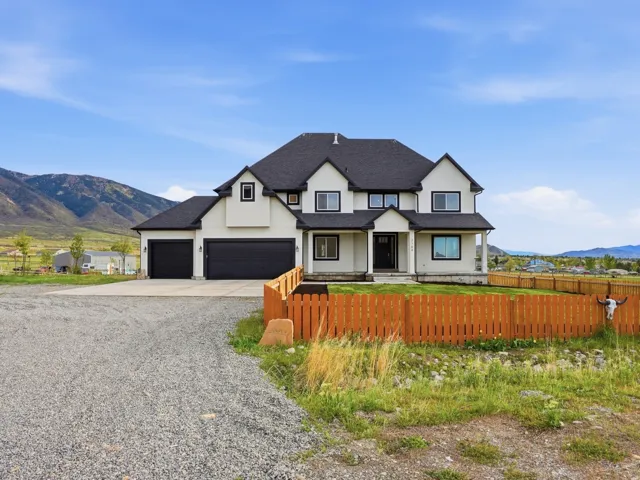 Modern farmhouse style home featuring a mountain view, covered porch, driveway, a shingled roof, and a garage