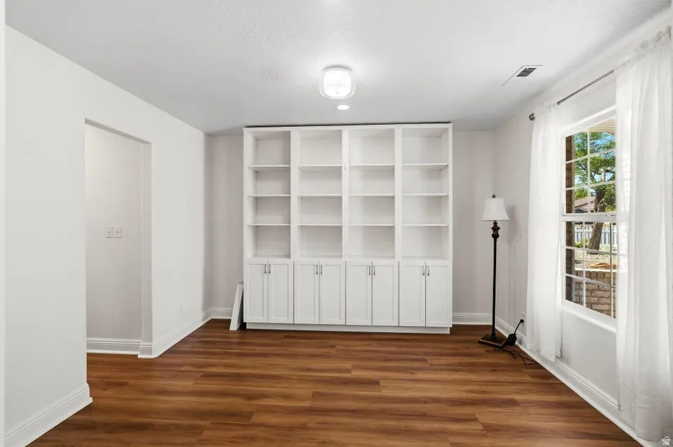 Unfurnished dining area featuring dark wood-type flooring