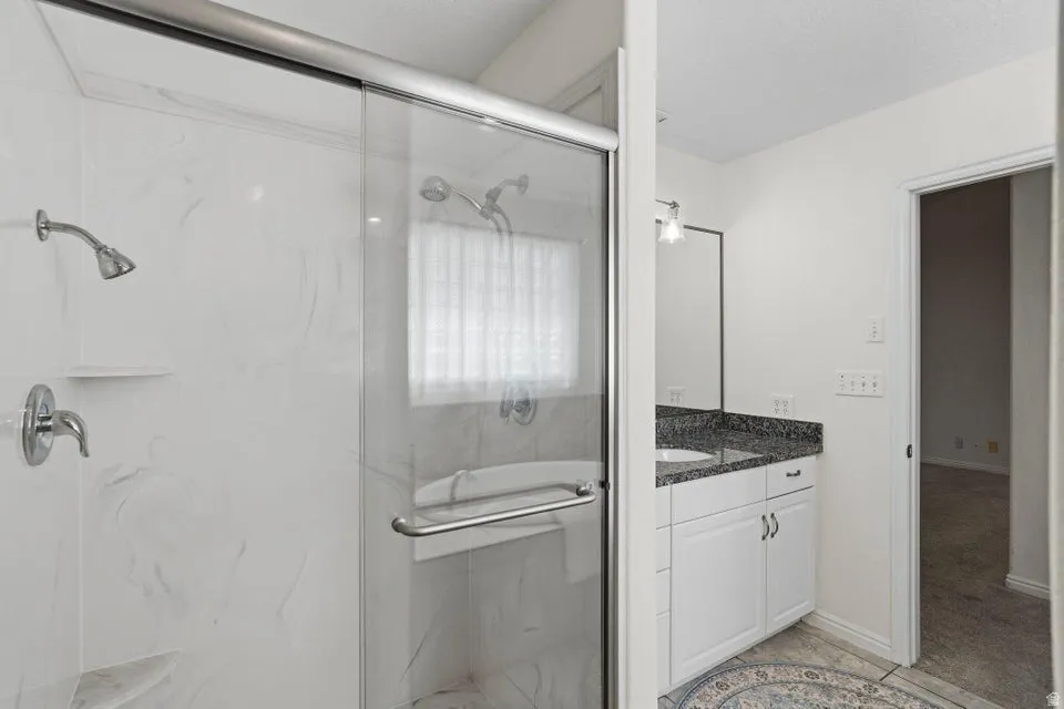 Full bathroom with vanity and a marble finish shower