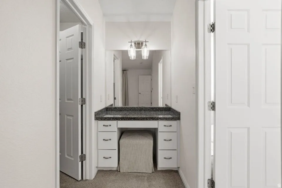 Bathroom with vanity and light colored carpet