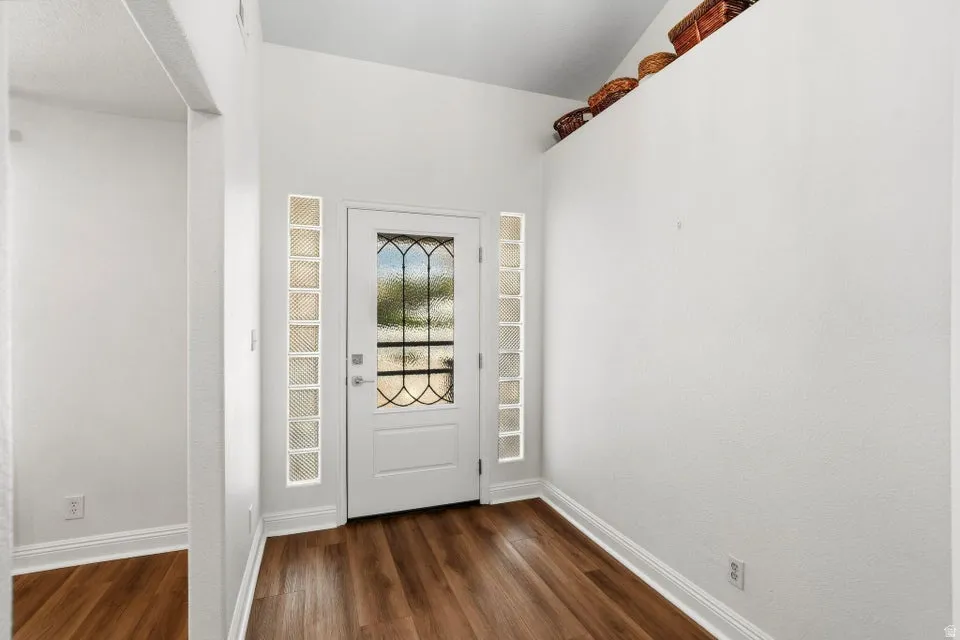 Entryway featuring baseboards and dark wood-type flooring