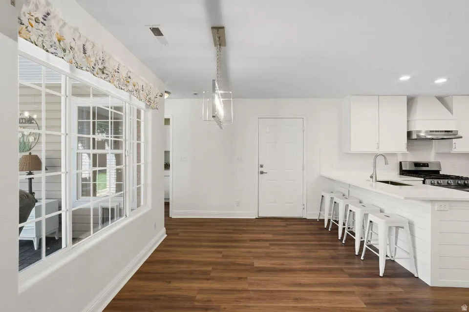 Dining room with dark wood-style floors and recessed lighting