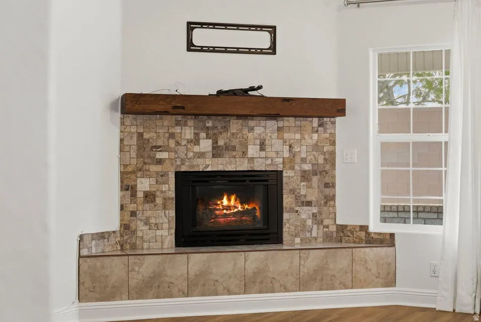 Detailed view of a tiled fireplace and wood finished floors